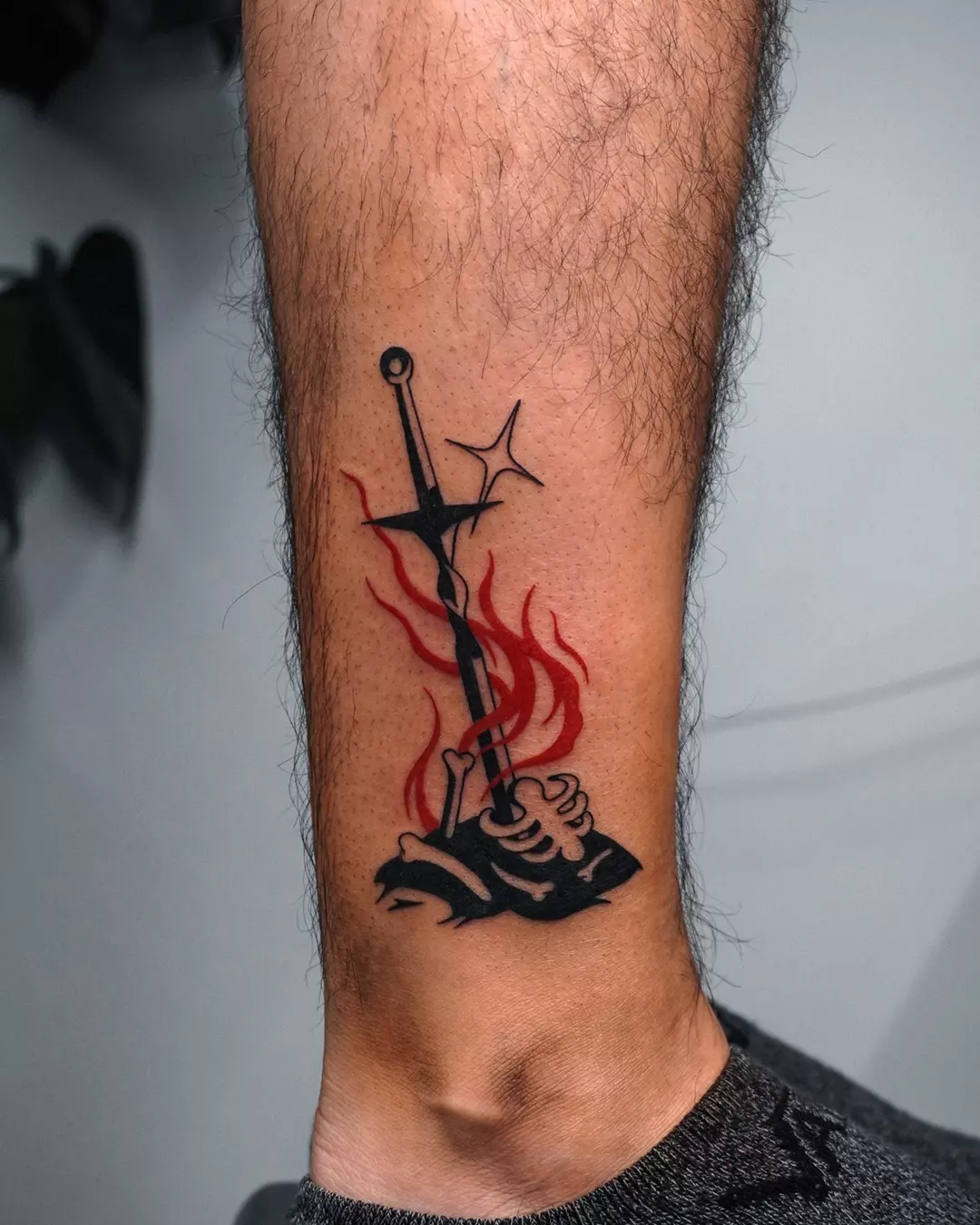 Sword and flames black and grey tattoo on the forearm by Jeremy "Jerms" Camposanto