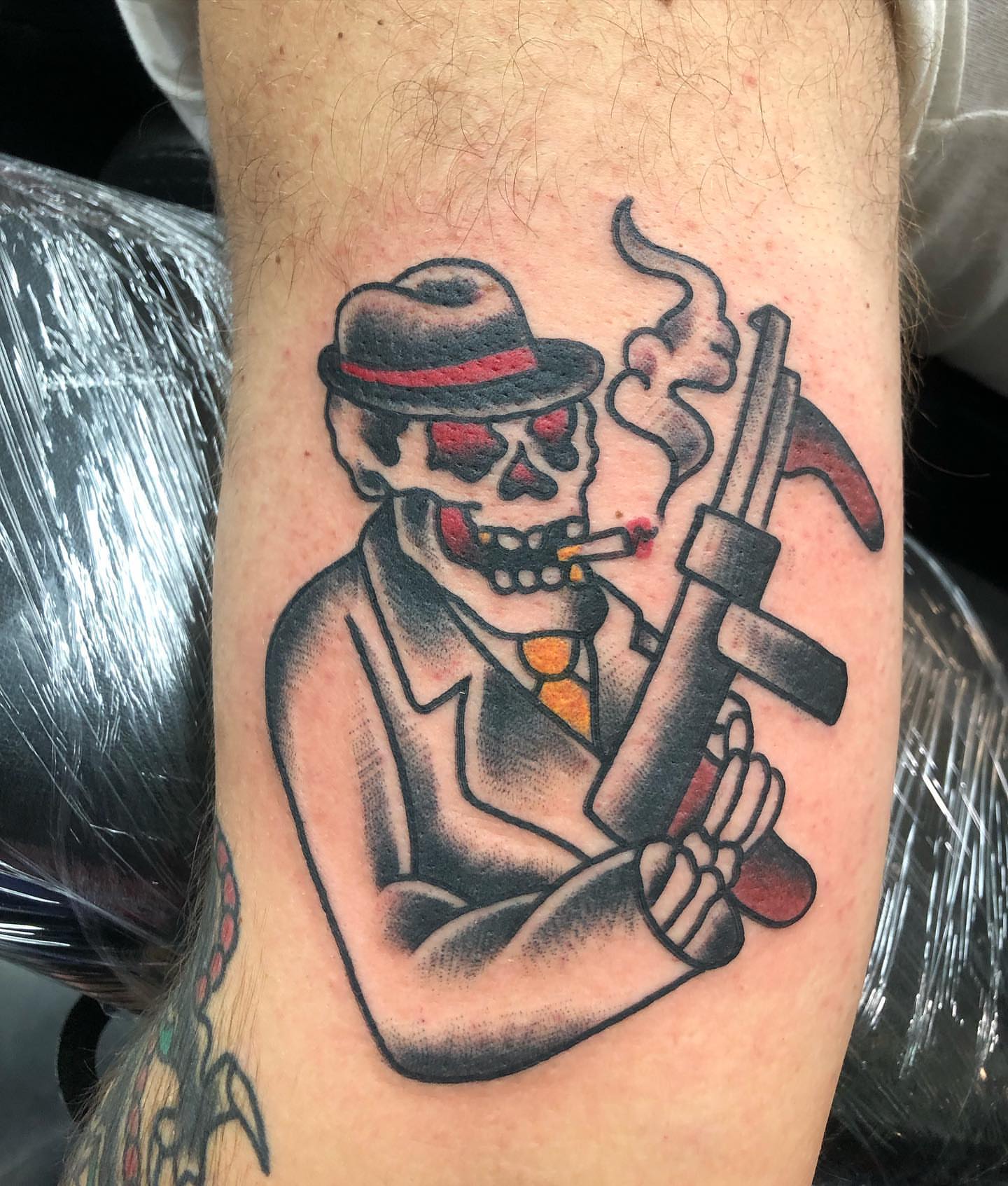 Gangster skeleton American traditional tattoo on the forearm by Brent G