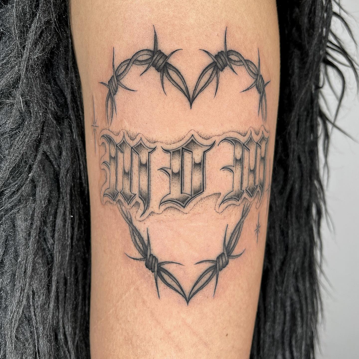 Barbed wire heart black and grey tattoo on the forearm by Tiyanna Garlic