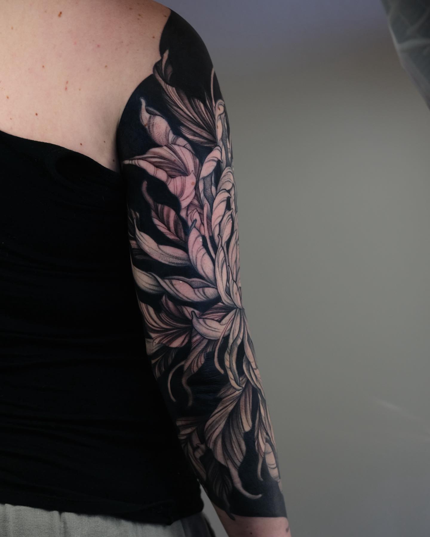 Lotus flower black and grey tattoo on the upper arm by 𝒕𝒂𝒕𝒕𝒐𝒐𝒔 𝒃𝒚 𝔏𝔞𝔲𝔯𝔢𝔫 𝔐𝔬𝔫𝔣𝔬𝔯𝔱𝔢