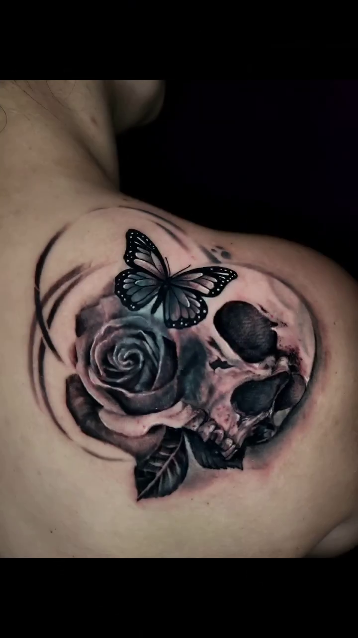 Skull, rose, and butterfly dark realism tattoo by Adrian Gonzalez
