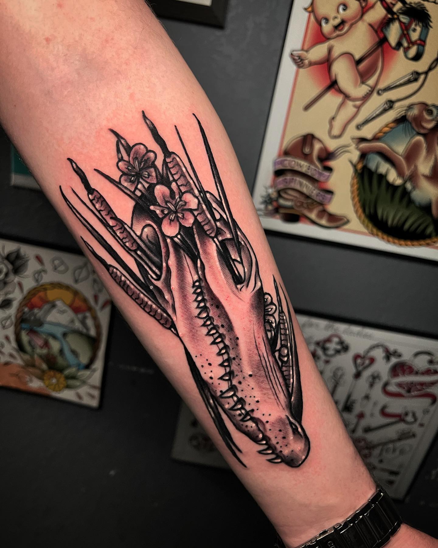 Dragon skull with flowers American traditional tattoo on the forearm by Raul Ortiz