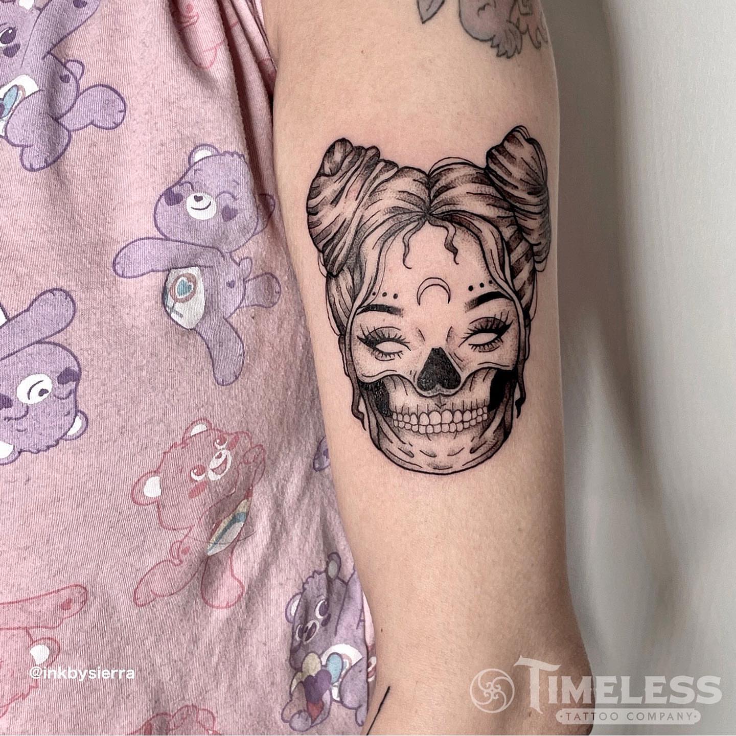 Skull with hair black and grey tattoo on the forearm by Sierra Seton