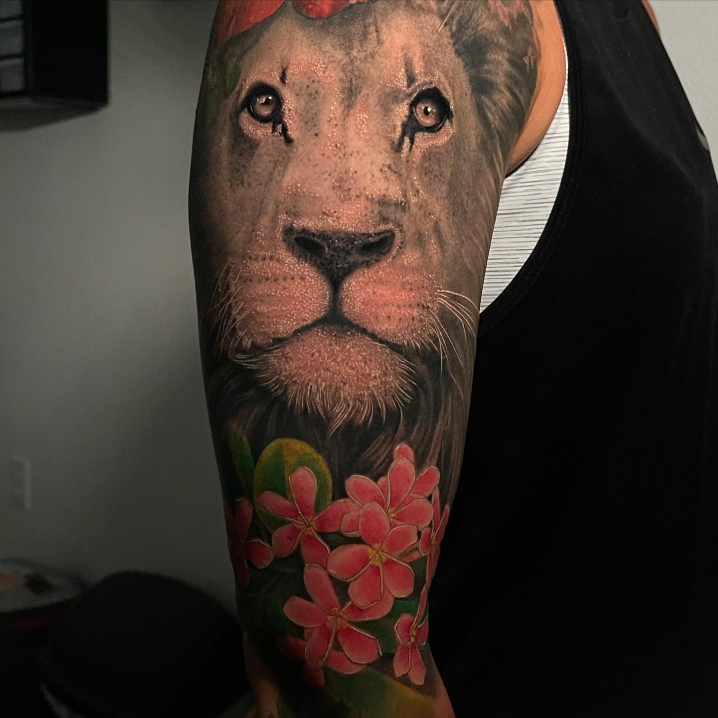 Lion and flowers realism tattoo on the forearm by Cuzmatt