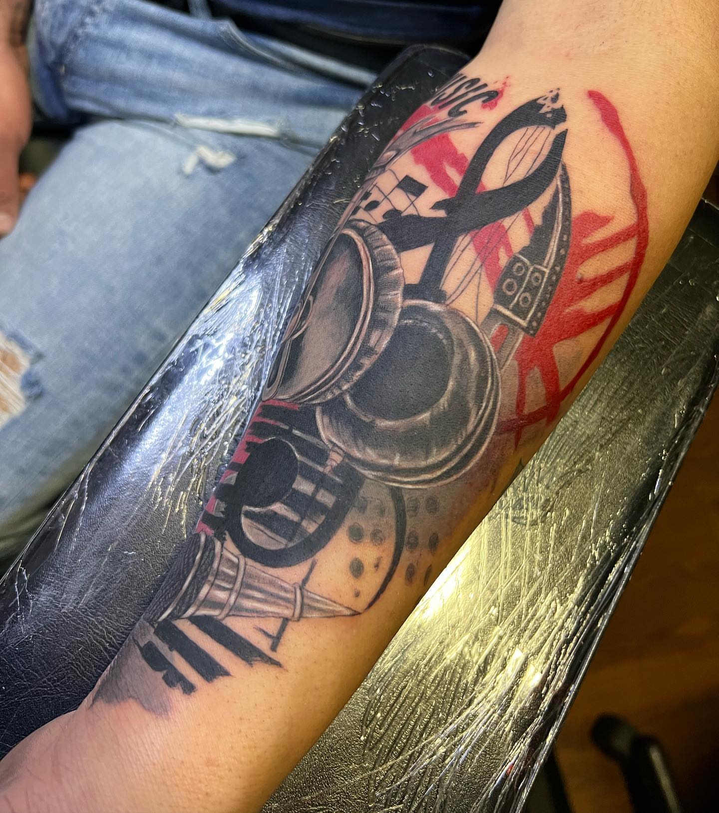 Headphones and ankh realism tattoo on the forearm by JT Ink