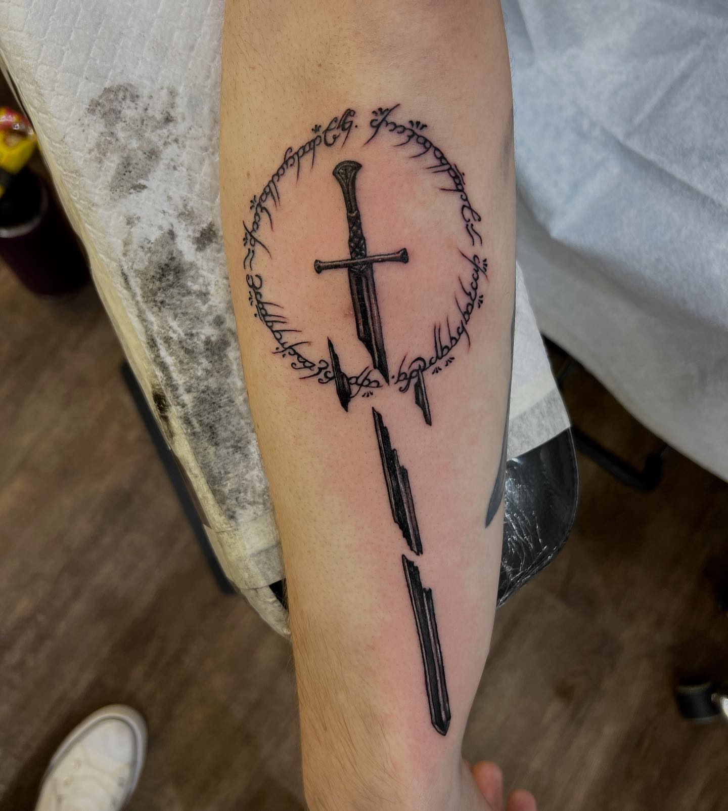 Sword and elvish runes black and grey tattoo on the forearm by πππ¦