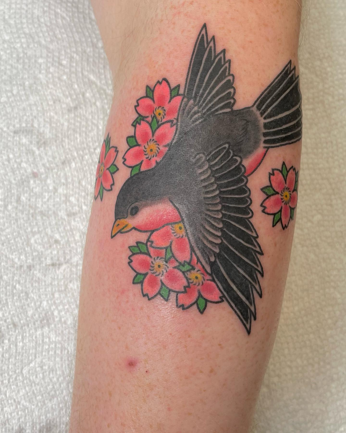 Bird and flowers American traditional tattoo on the forearm by Seth Griffin