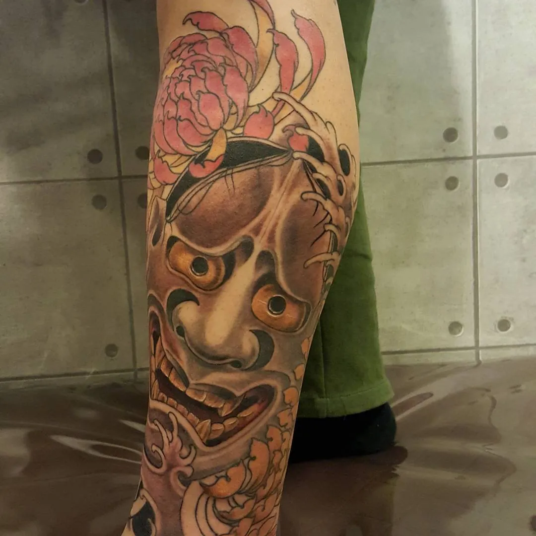 Mask and flowers japanese irezumi tattoo on the calf by zamix_traditional, San Francisco, California