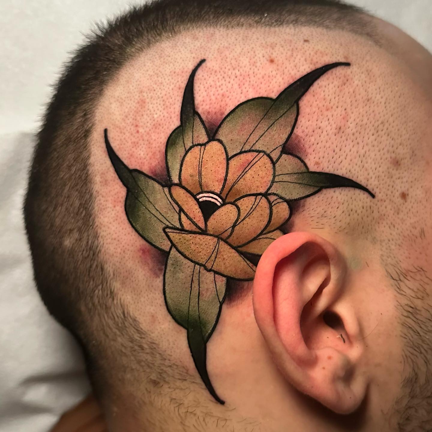 Lotus flower American traditional tattoo on the head by gillian marie