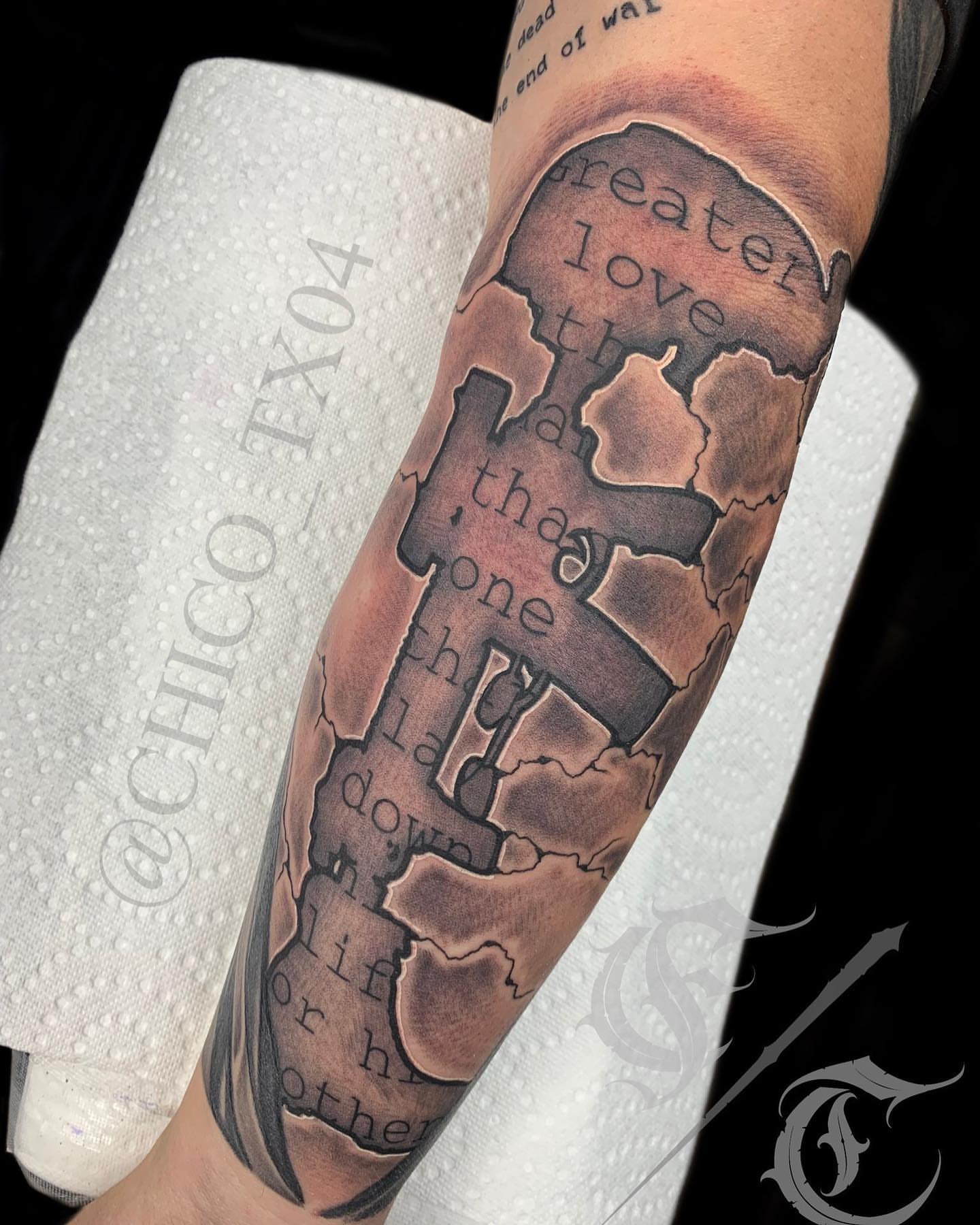 Cross and text black and grey tattoo on the forearm by Tattoos By Chico