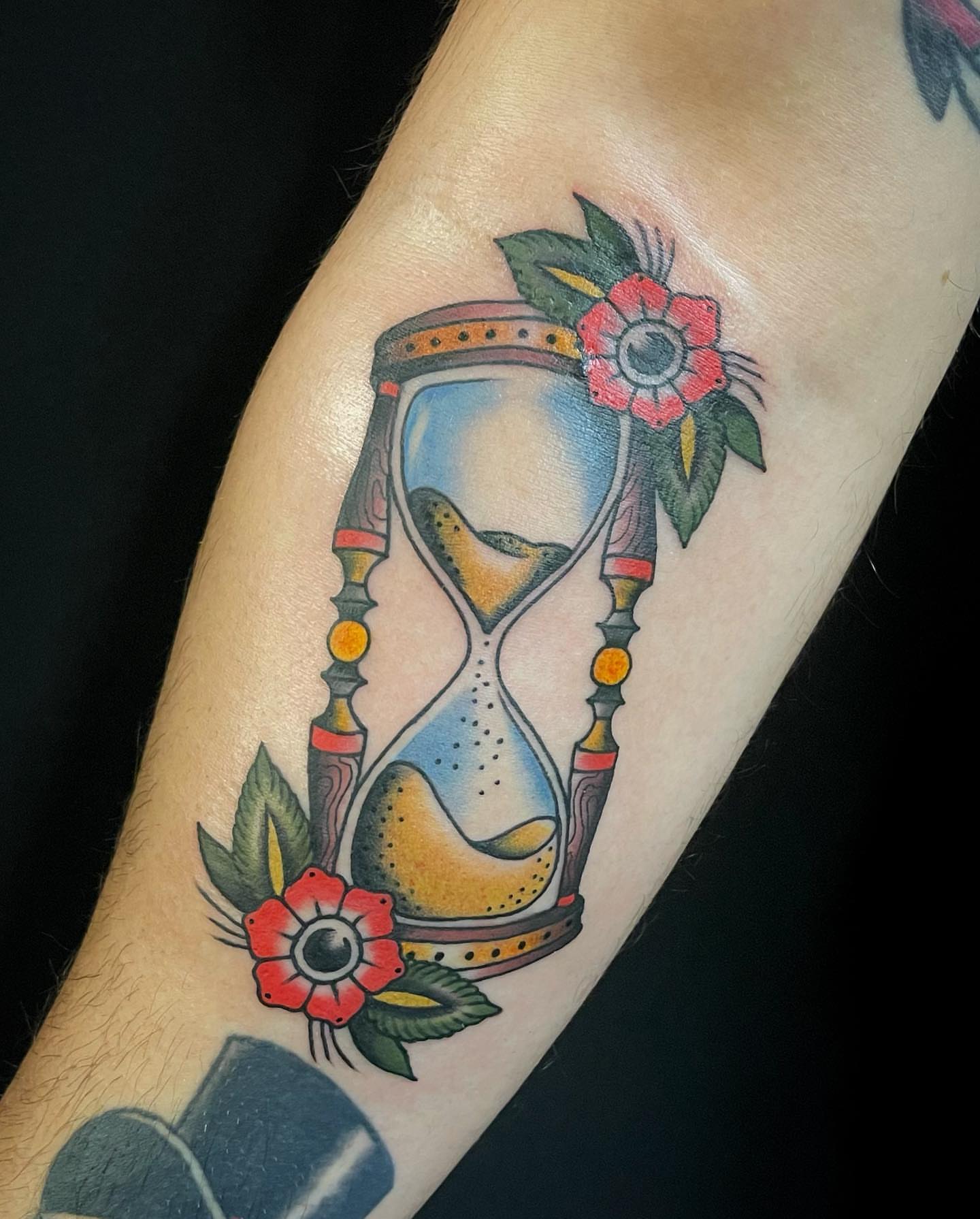 Hourglass and flowers American traditional tattoo on the forearm by Lexx Christine