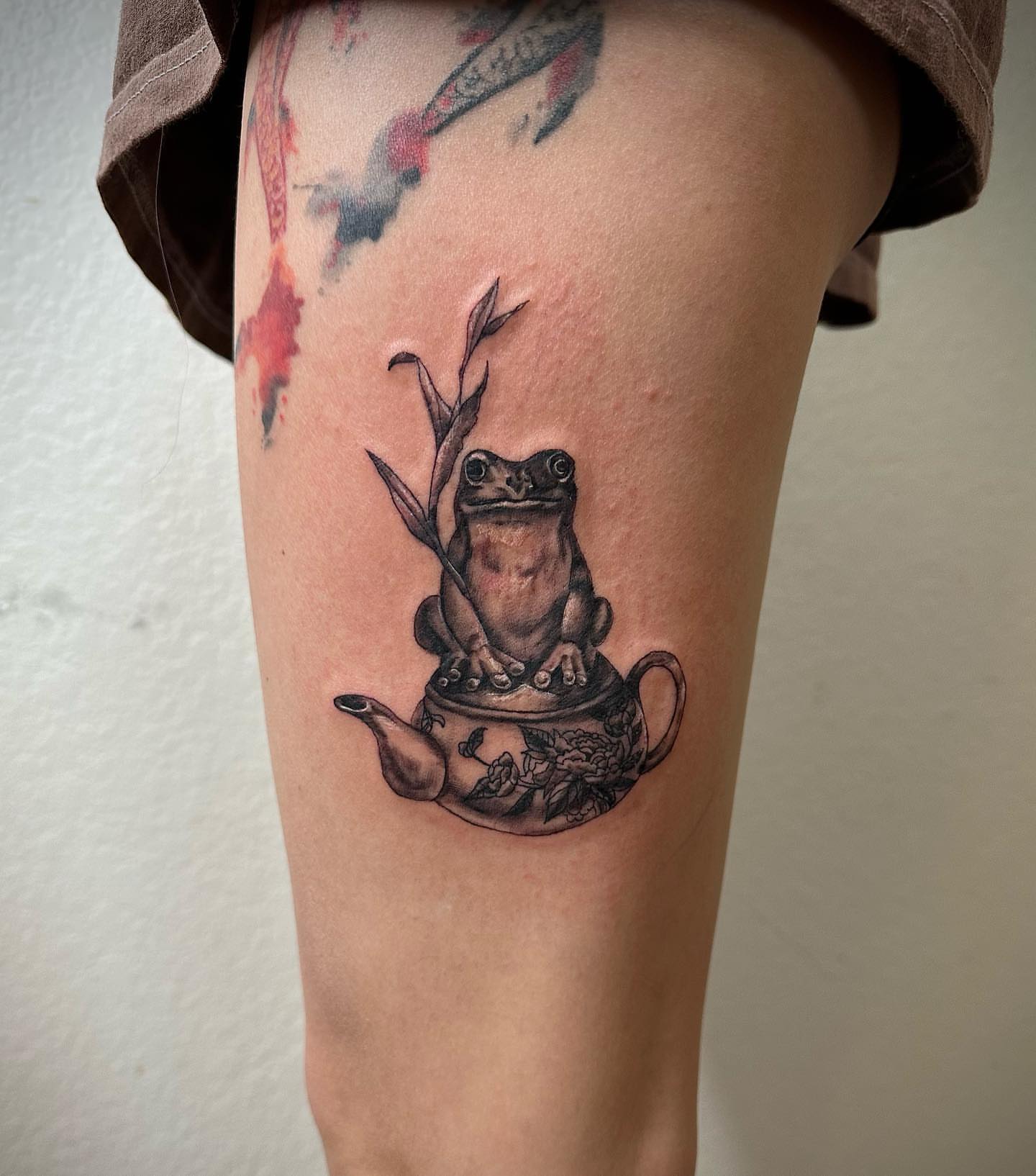 Frog on teapot realism tattoo on the thigh by Leo Torres