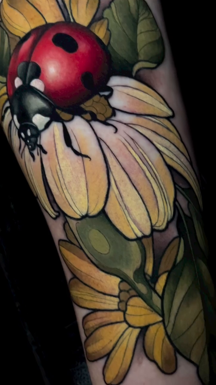 Ladybug on a daisy neo-traditional tattoo by Evin Pfaff, Bedford, Pennsylvania