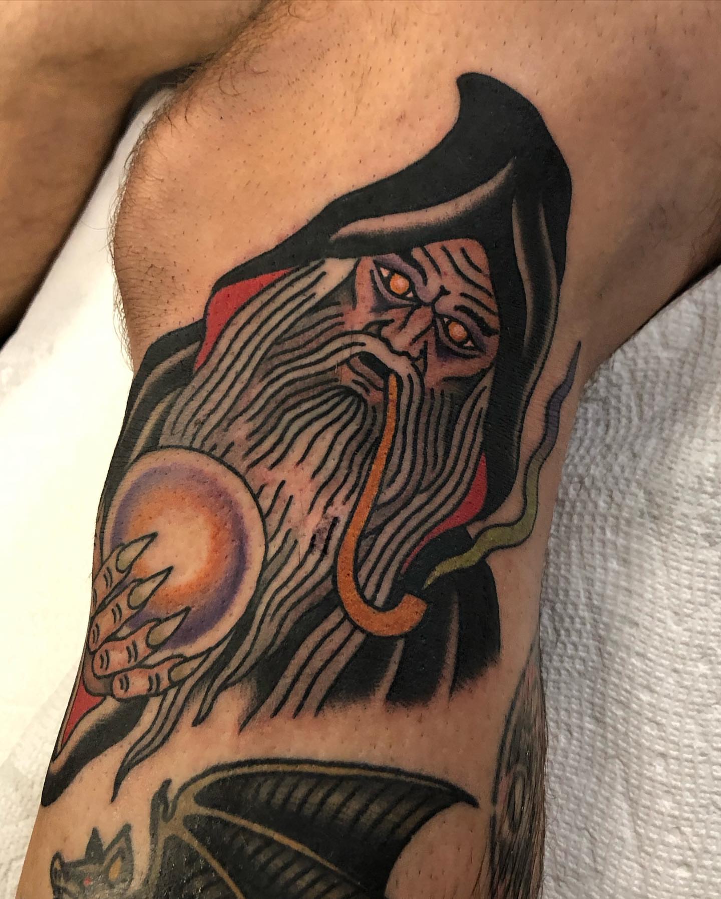 Demon with orb American traditional tattoo on the forearm by Ben Fiedler
