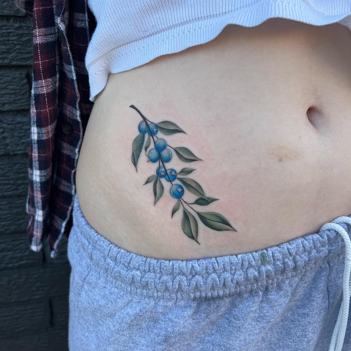 Blueberry branch realism tattoo on the ribs by Blu