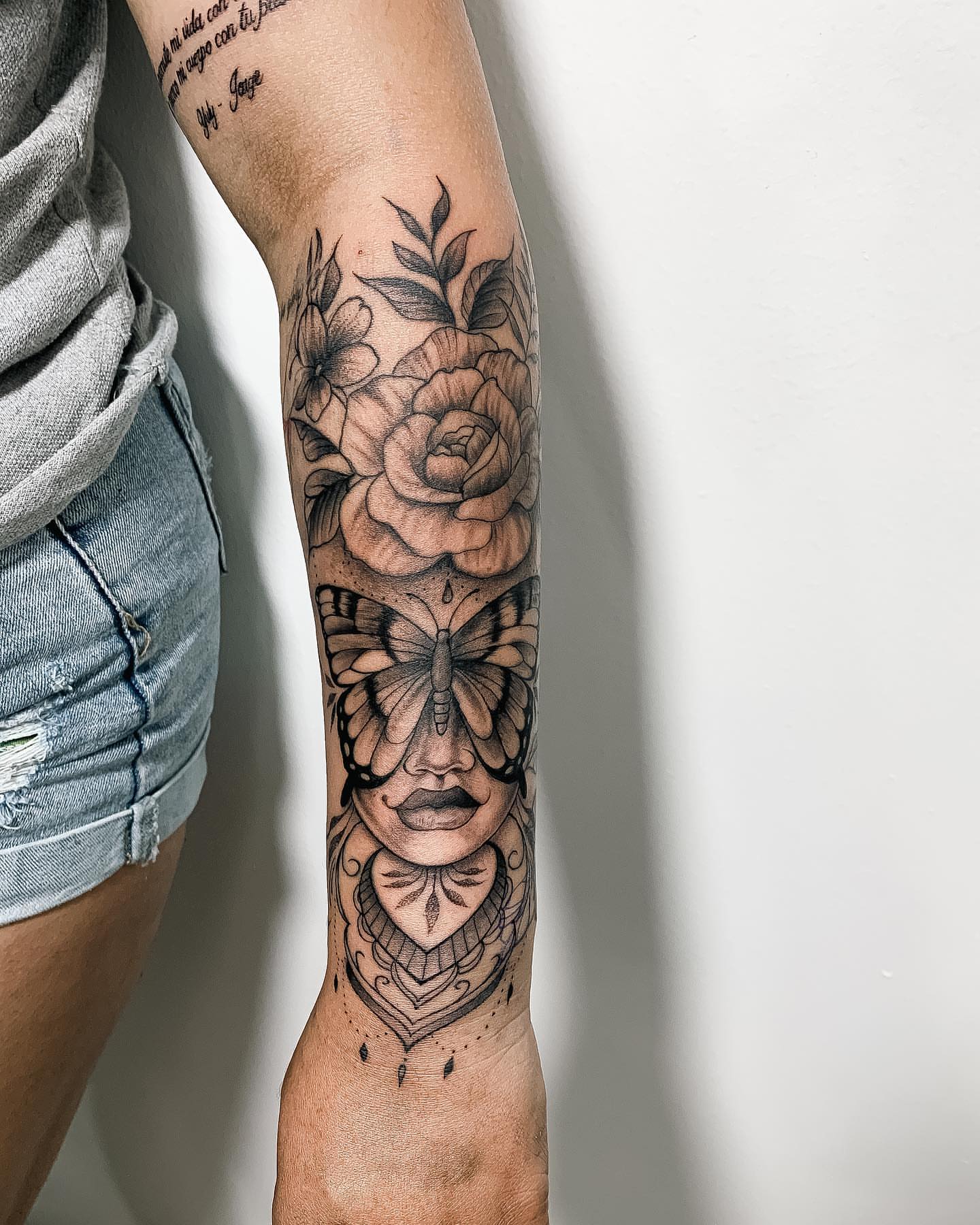Woman's face with butterfly American traditional tattoo on the forearm by 𝔄𝔩𝔳𝔞𝔯𝔬 𝔓𝔦𝔫𝔦𝔩𝔩𝔞