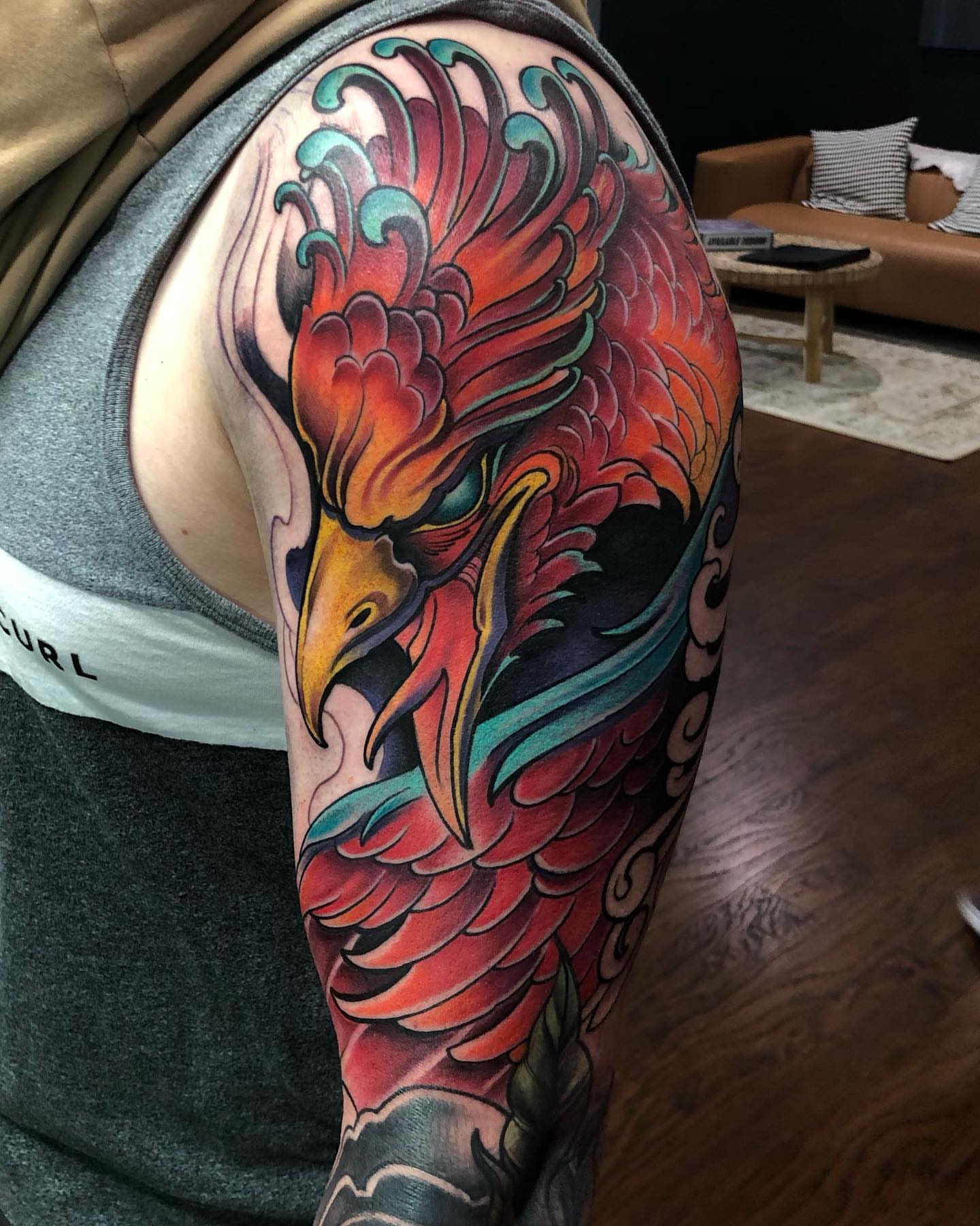 Phoenix American traditional tattoo on the upper arm by Aaron Borden