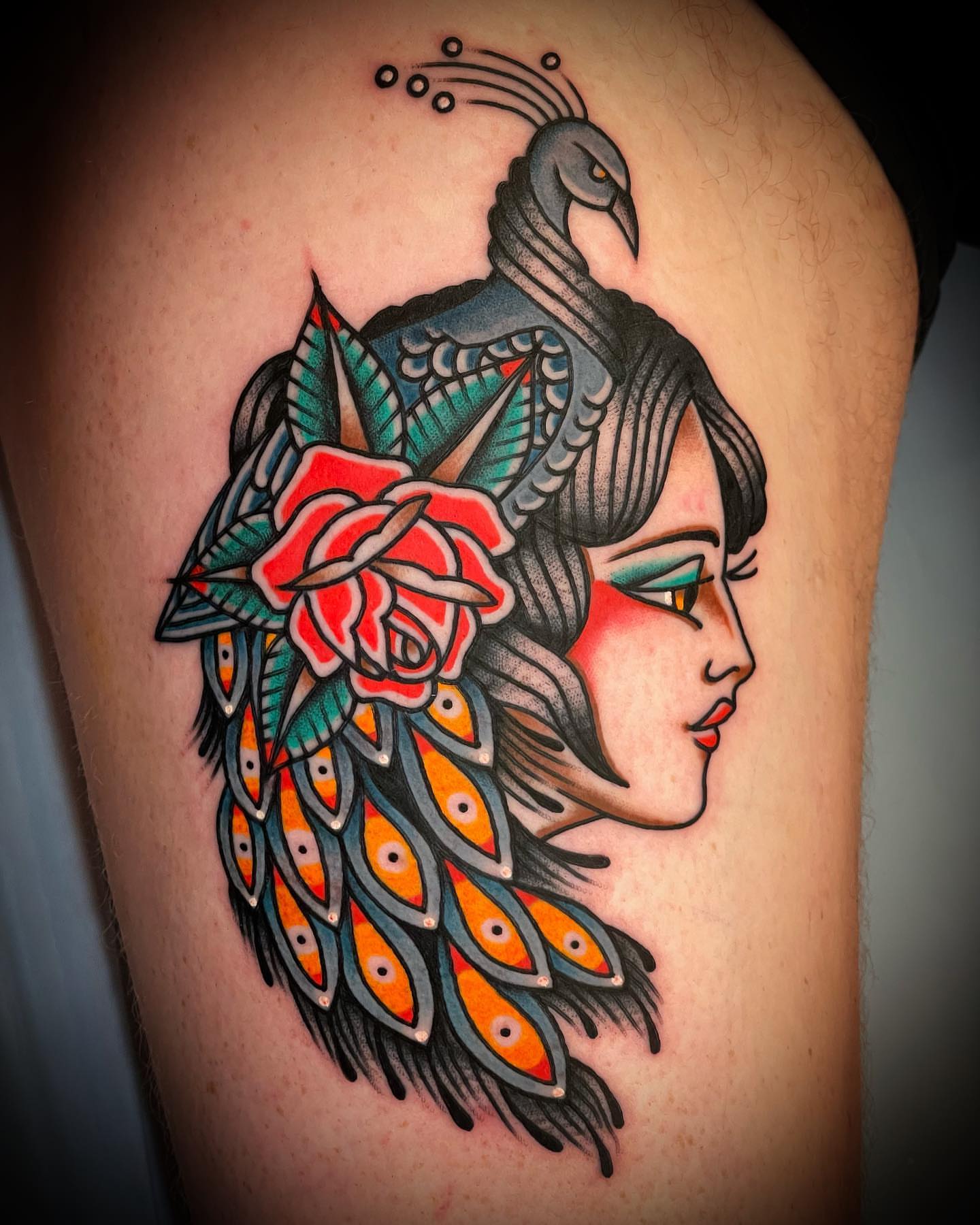Peacock and woman American traditional tattoo on the thigh by Alex Muniz