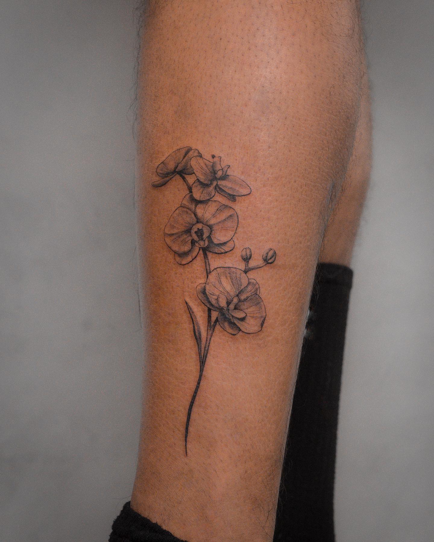 Orchids black and grey tattoo on the forearm by Mateo