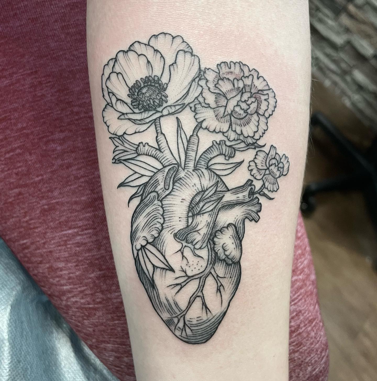 Anatomical heart with flowers realism tattoo on the forearm by Kirsten Marsden Ballantyne