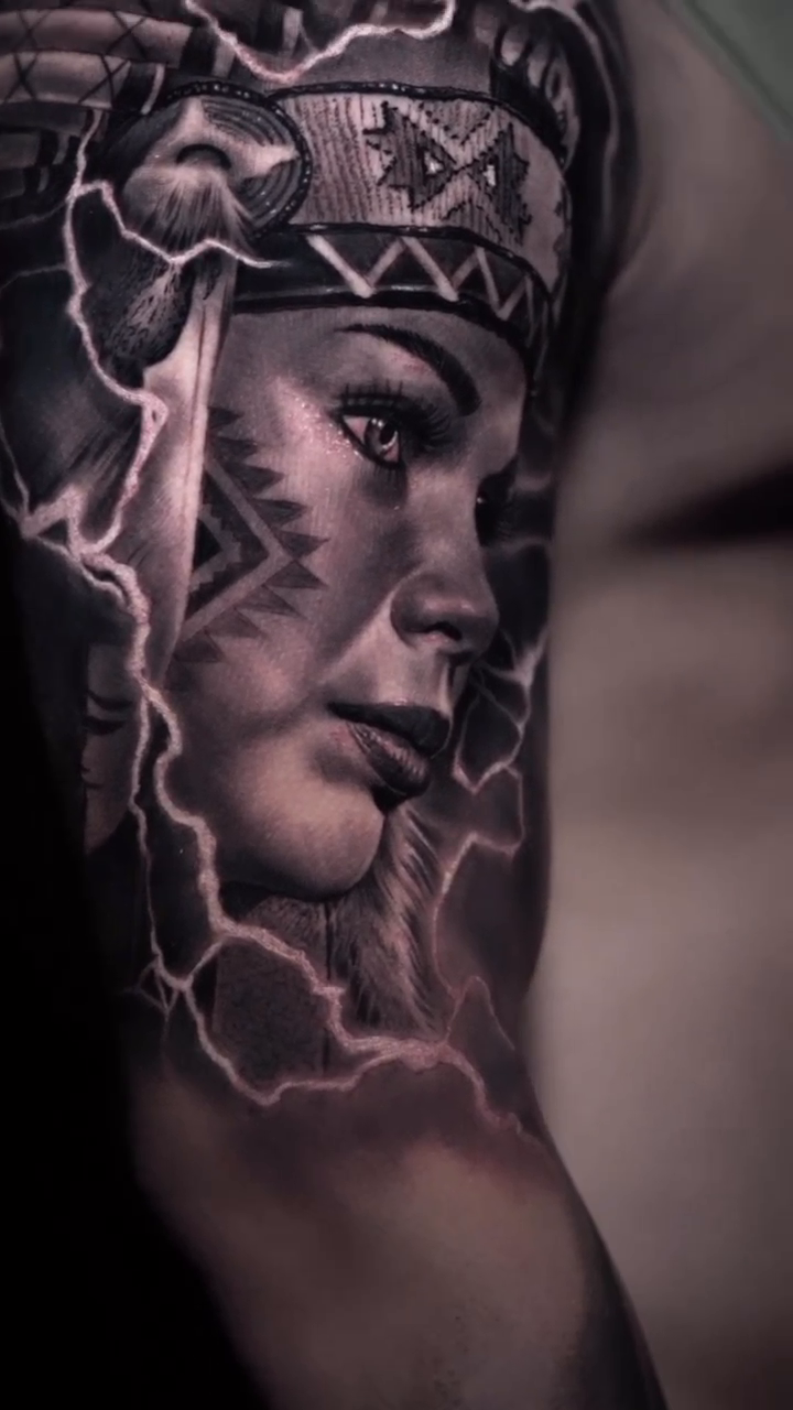 Native American woman with headdress realism tattoo by Tattoos By Chino