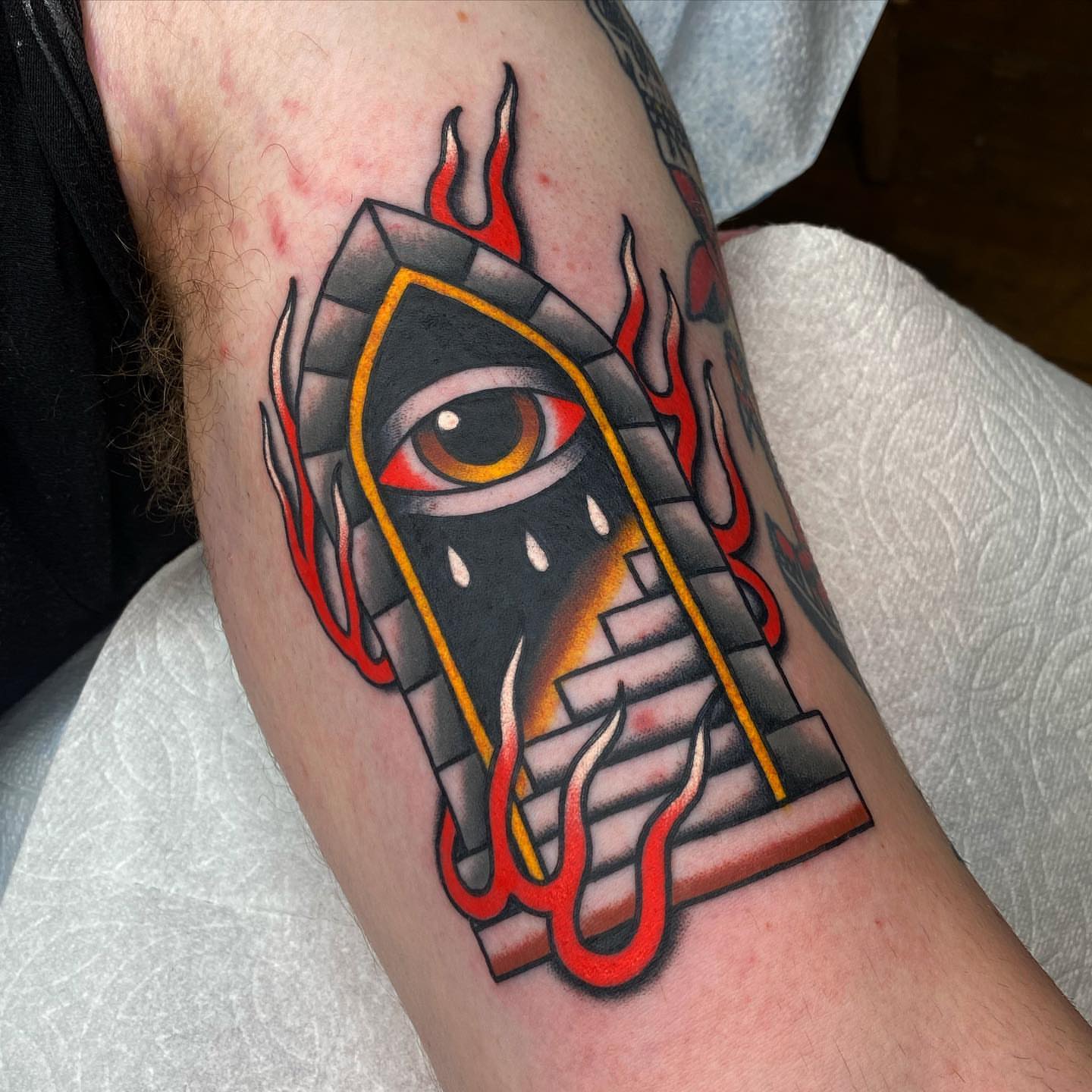 Eye with flames American traditional tattoo on the forearm by andrewtattoos