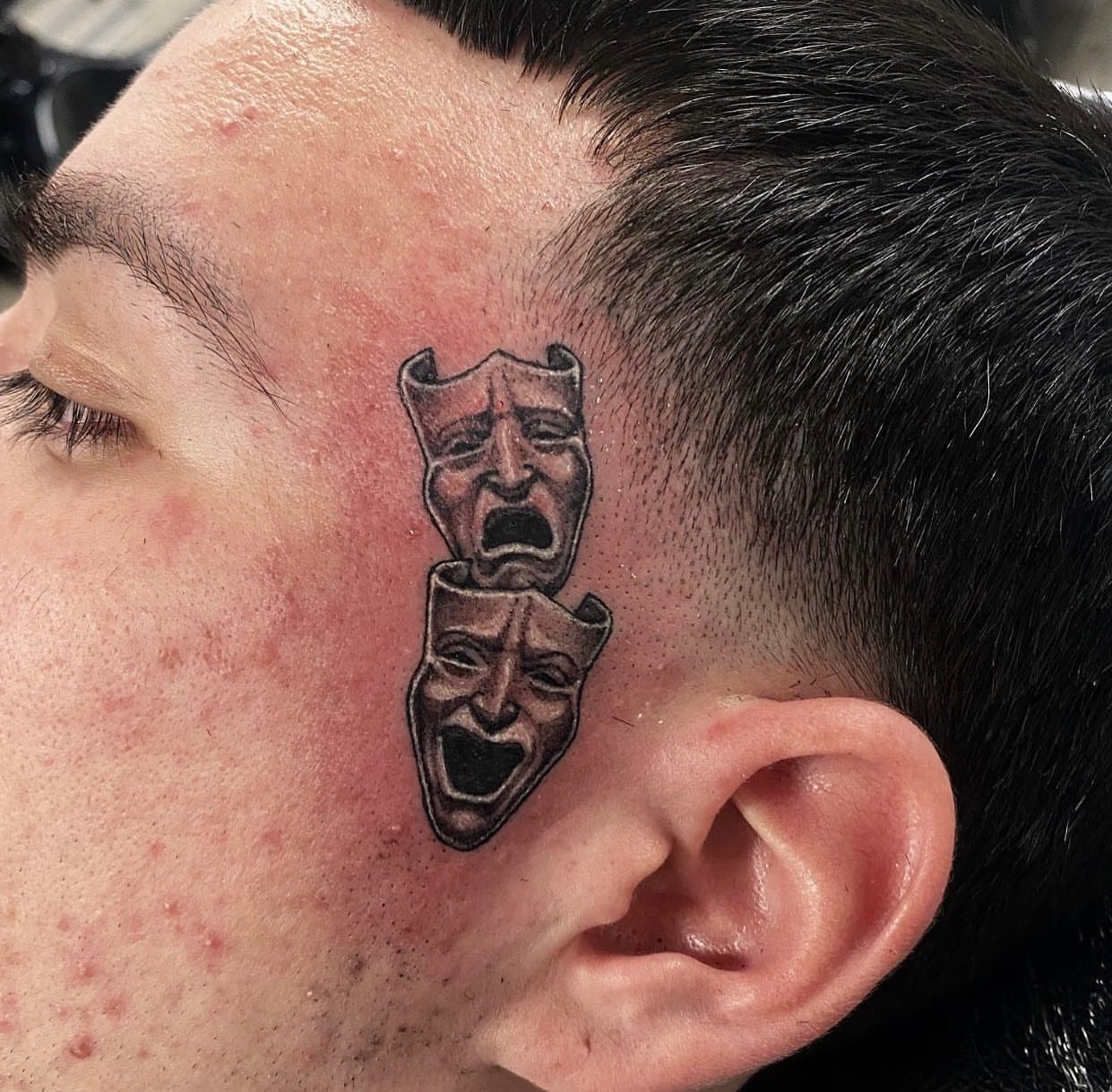 Theater masks black and grey tattoo on the head by Justin Hendrick