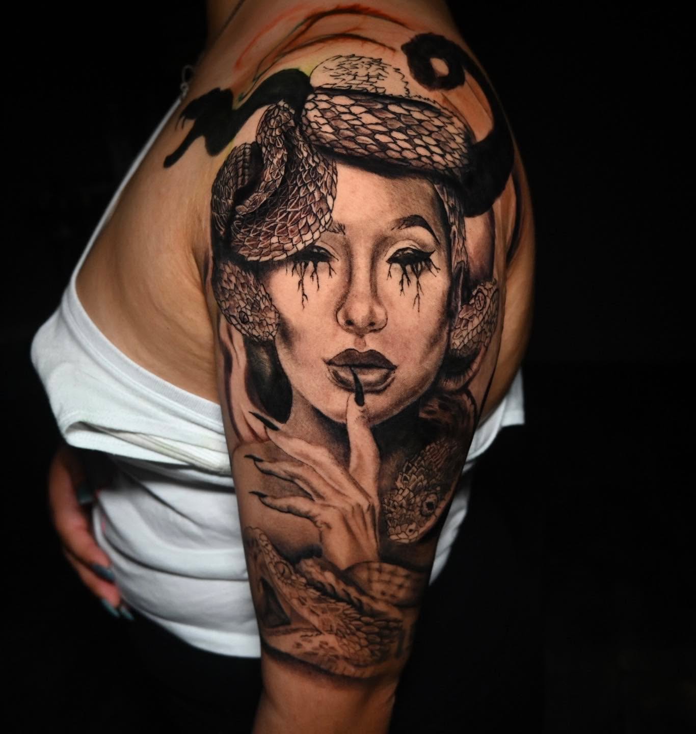 Woman with snake realism tattoo on the shoulder by BoogaInk