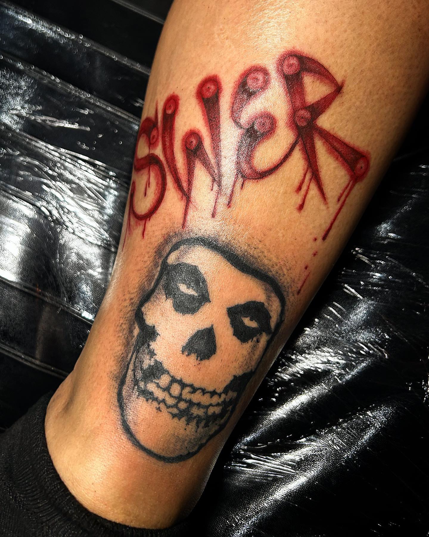 Skull and lettering black and grey tattoo on the forearm by Visionary Tattoos
