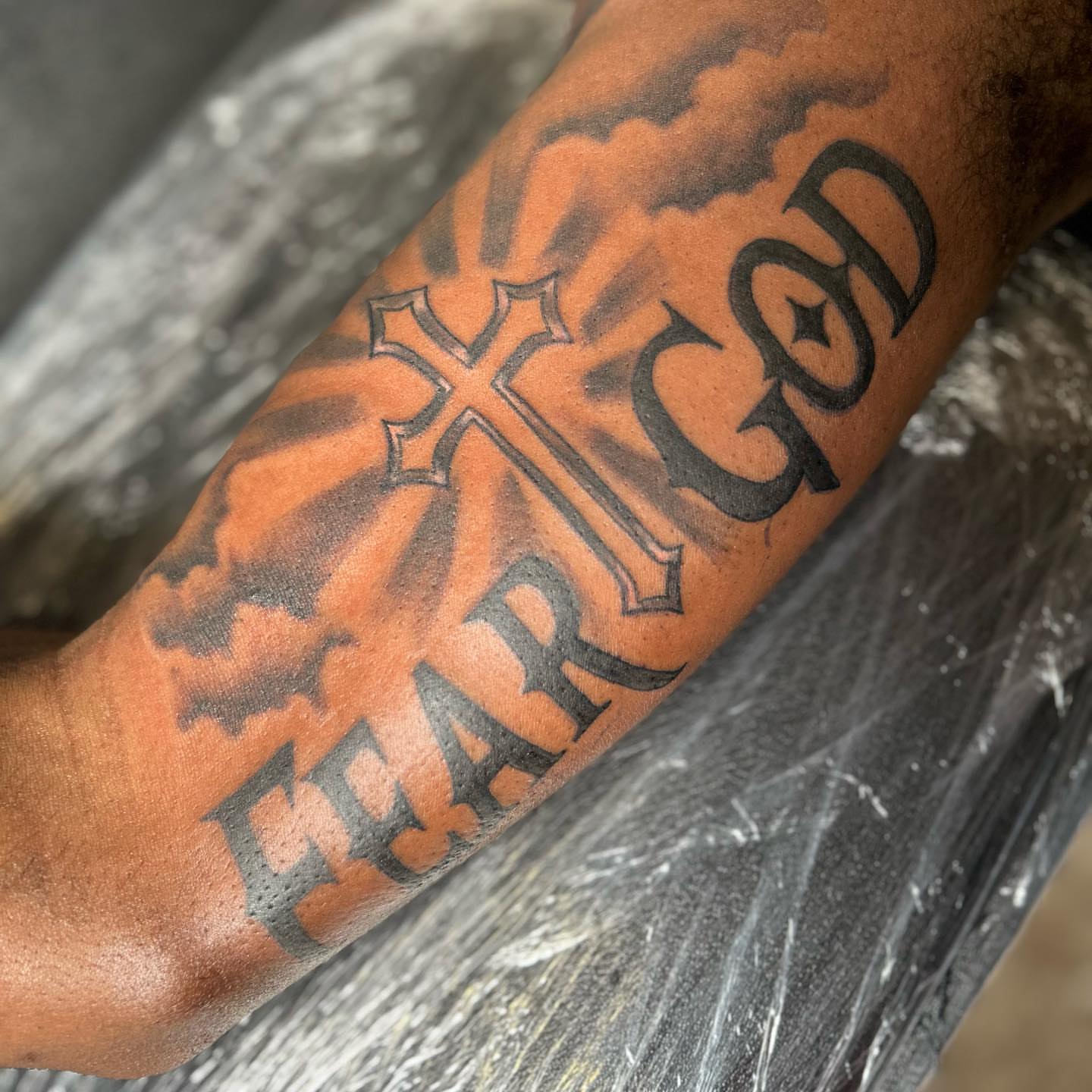 Cross and text black and grey tattoo on the forearm by Atl Tattoo Artist✍🏾👨🏾‍🎨