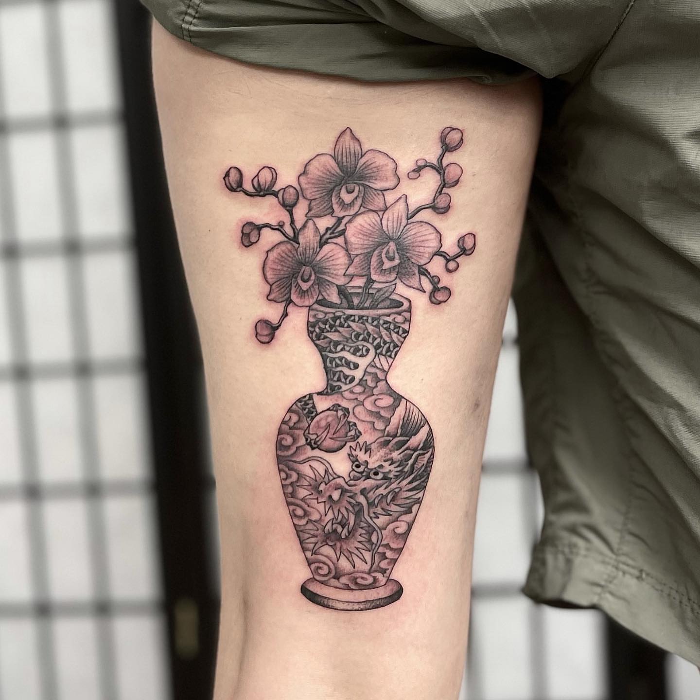 Vase with orchids realism tattoo on the thigh by Mister Joe Joe Frisco Tattoo, San Francisco, California