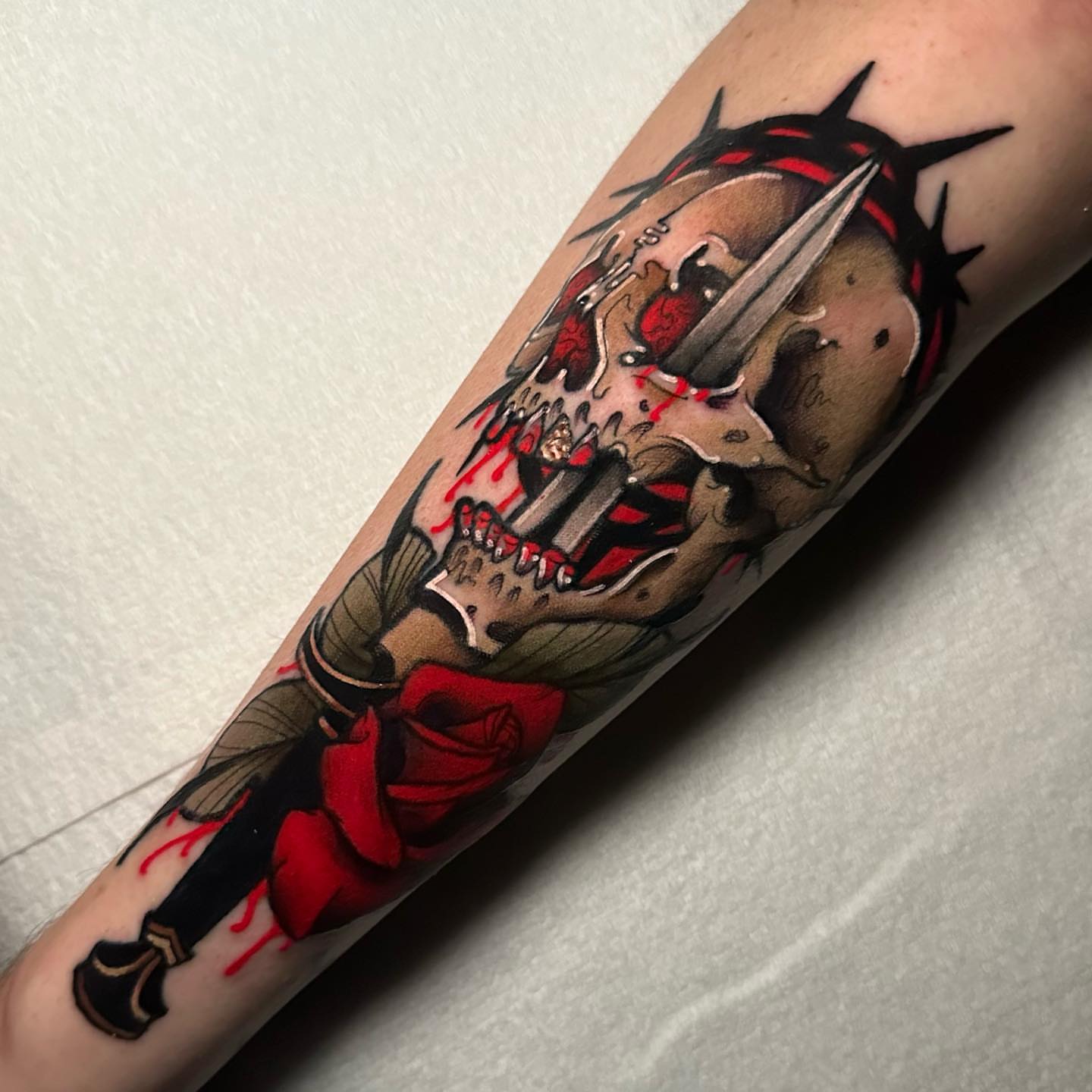 Skull with dagger dark realism tattoo on the forearm by gillian marie