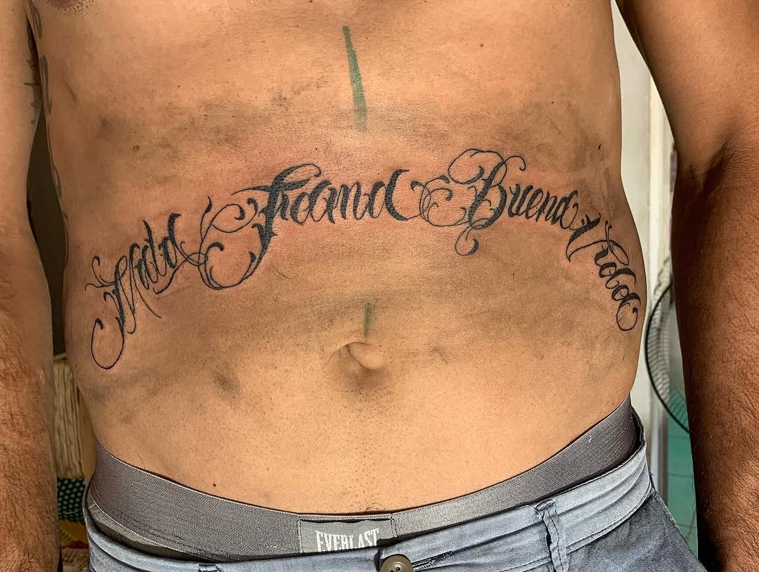 Script lettering Chicano tattoo on the chest by El Zepa