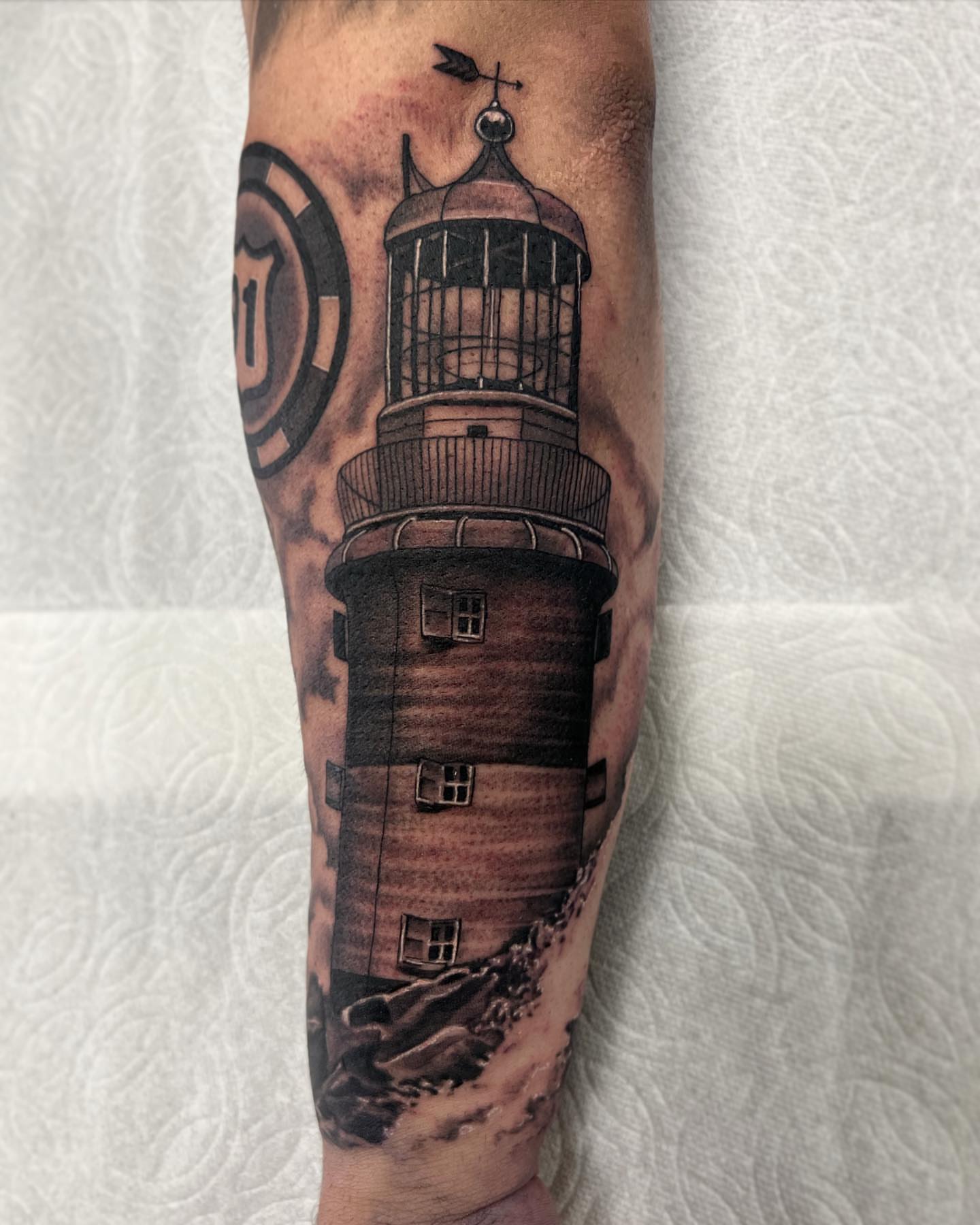 Lighthouse black and grey tattoo on the forearm by Nick Bridwell, Downey, California