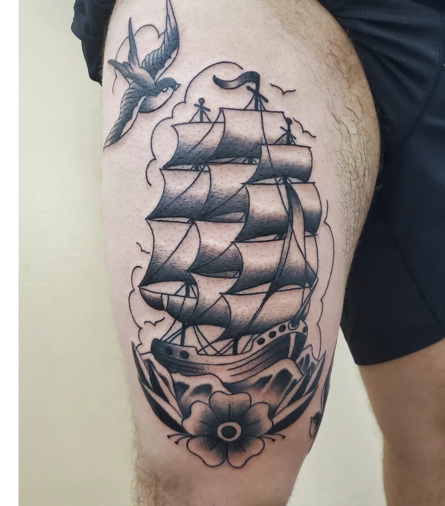 Sailboat and bird American traditional tattoo on the thigh by Ginny McCormick, Richmond, Virginia