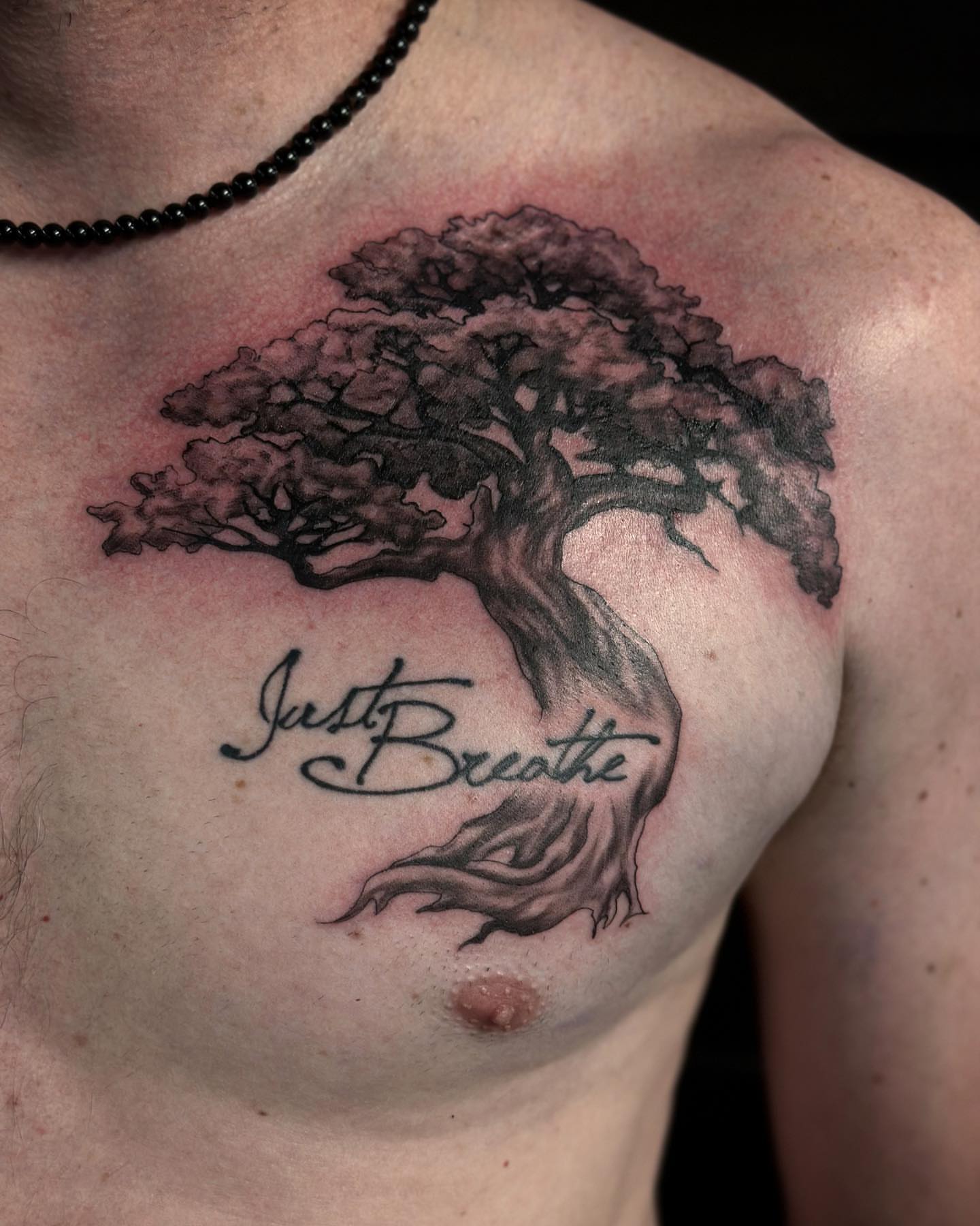 Tree with inspirational phrase black and grey tattoo on the chest by audi