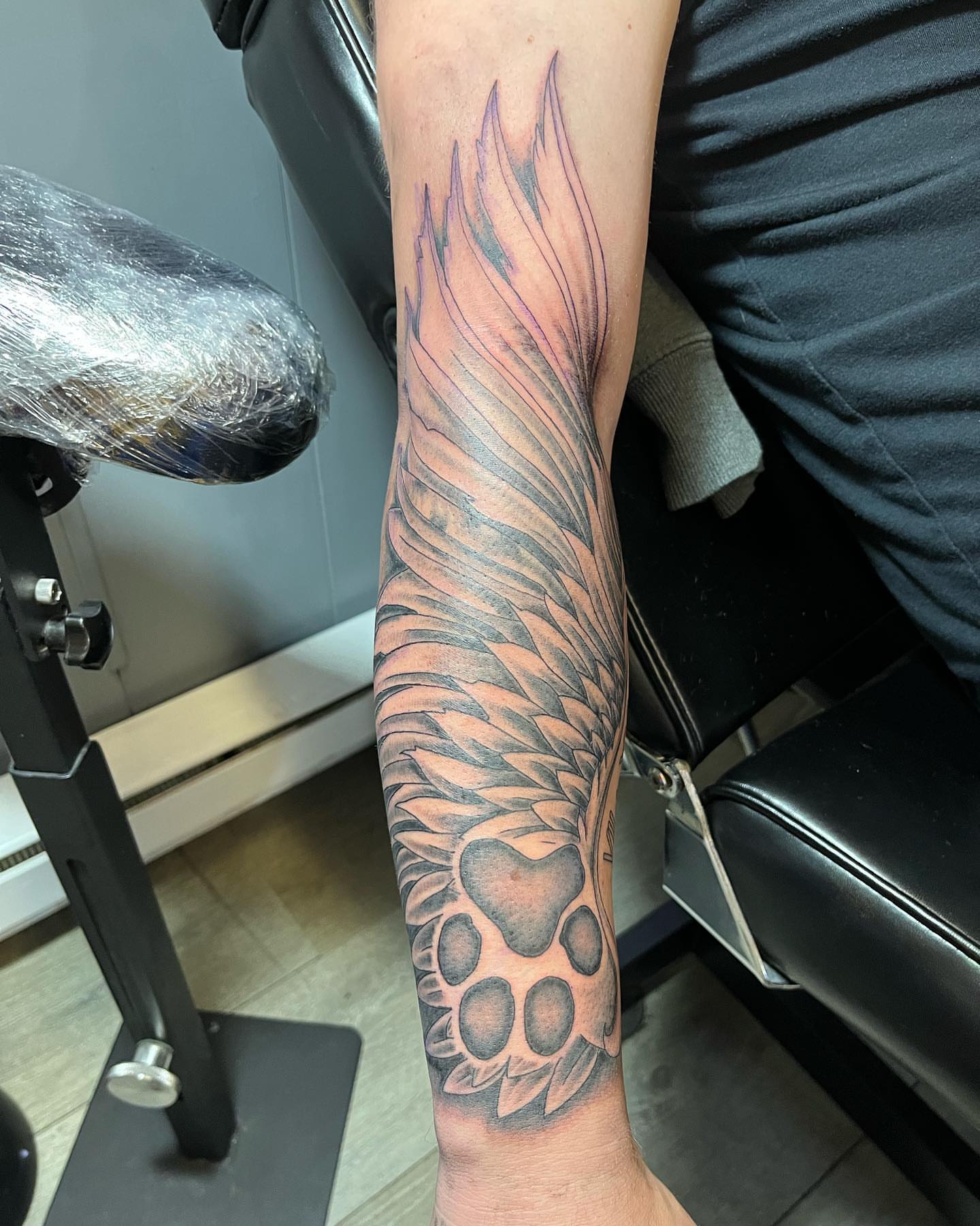 Wing and paw print black and grey tattoo on the forearm by Breanna💉🔮, Dover, Delaware