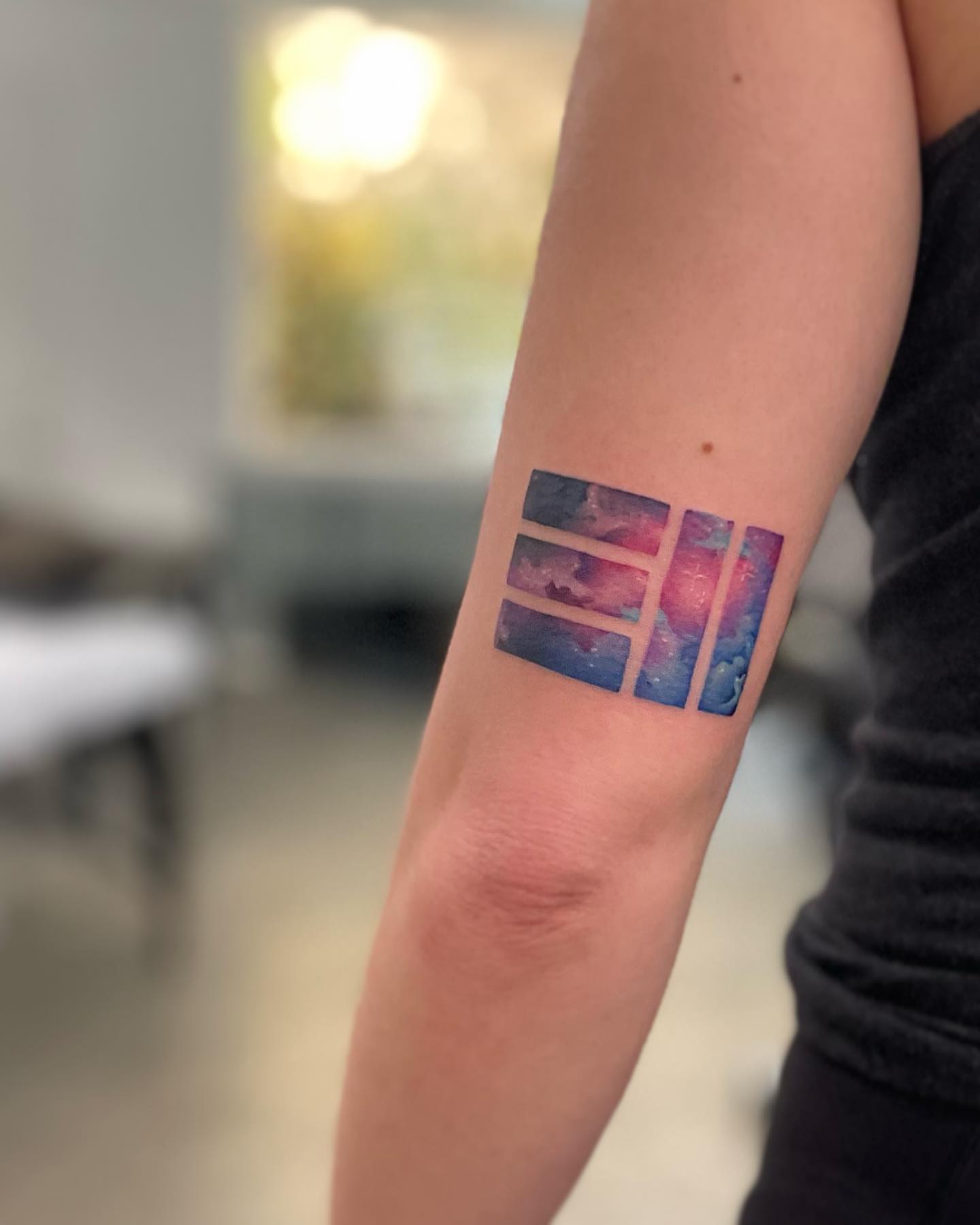 Galactic nebula geometric tattoo on the forearm by Georgia Grey