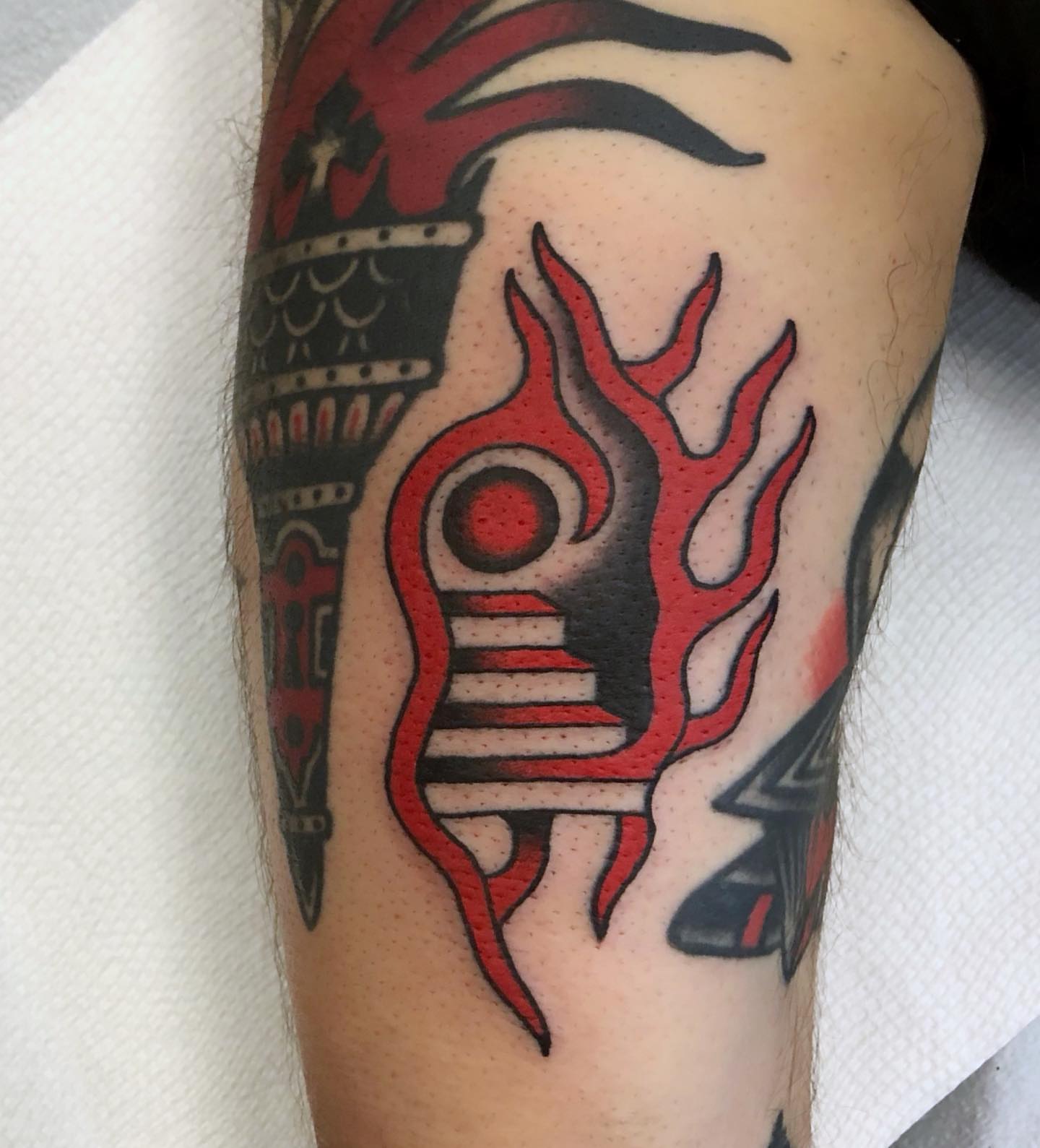Flame and shield neo-traditional tattoo on the forearm by Ben Fiedler