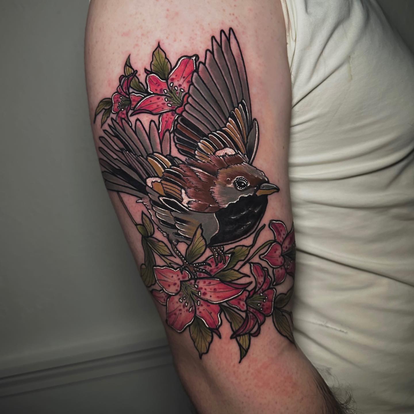 Bird and flowers realism tattoo on the forearm by Naysla Droguett