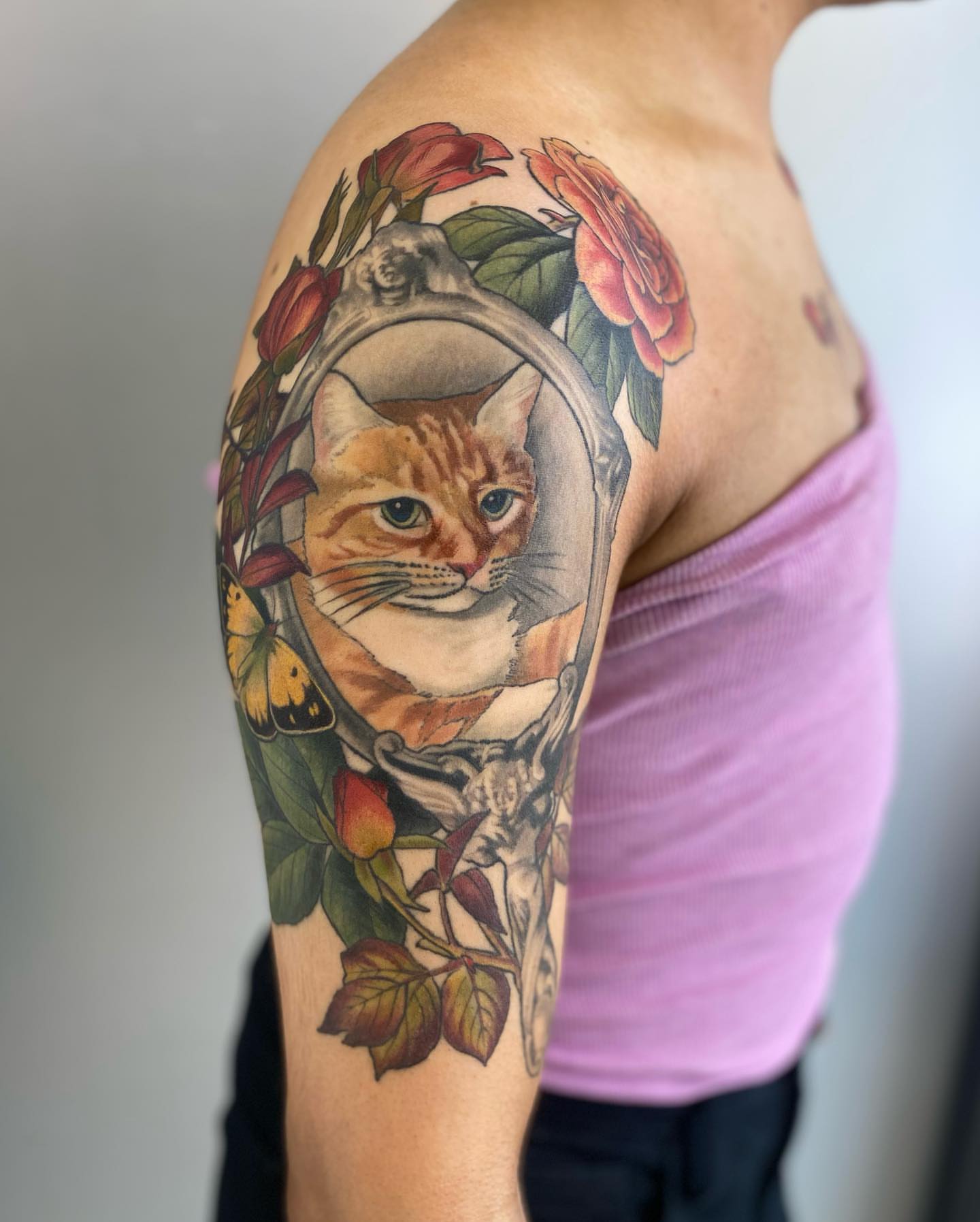 Cat in mirror realism tattoo on the upper arm by Rusty Indigo