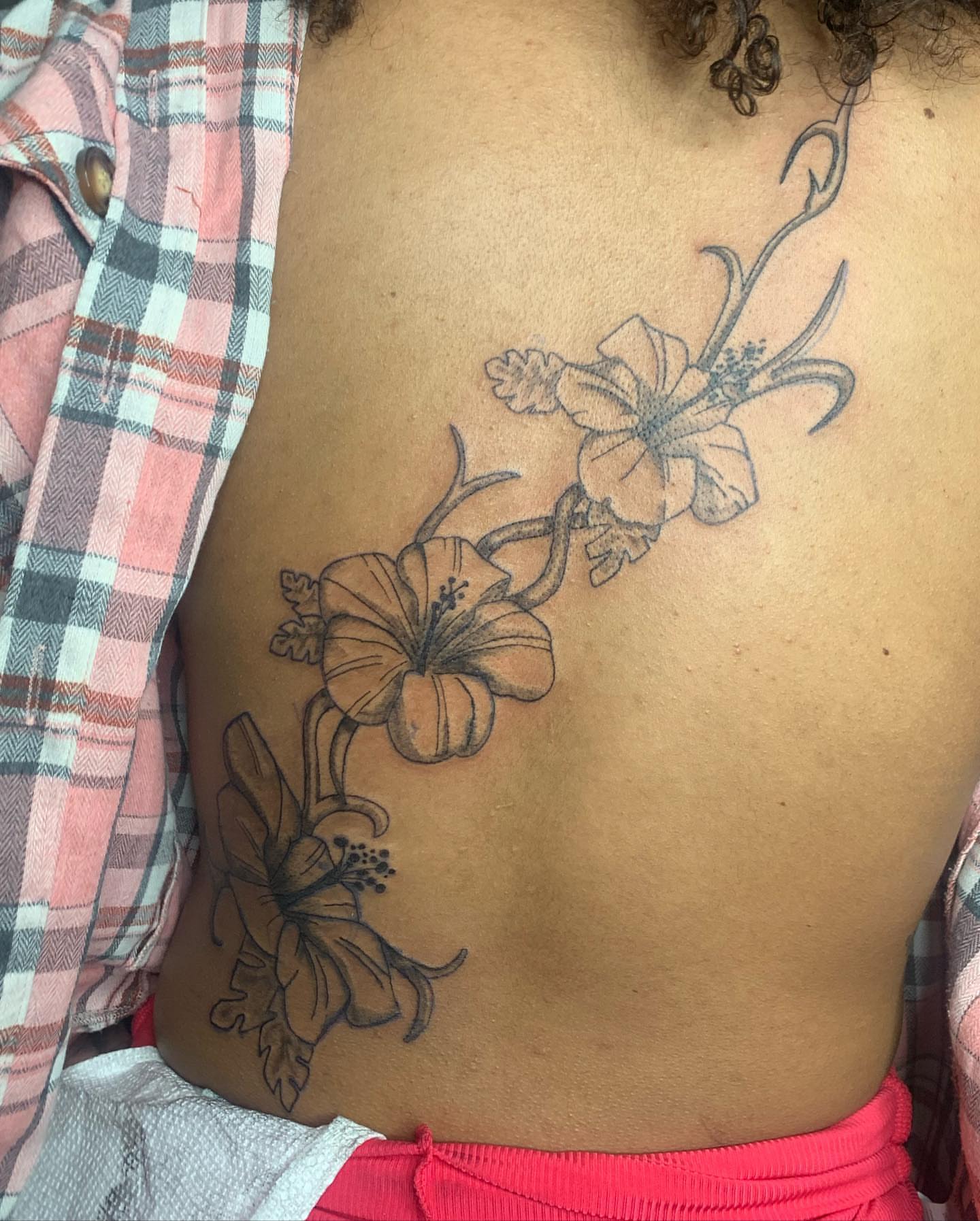 Hibiscus flowers black and grey tattoo on the chest by Evan Chastain