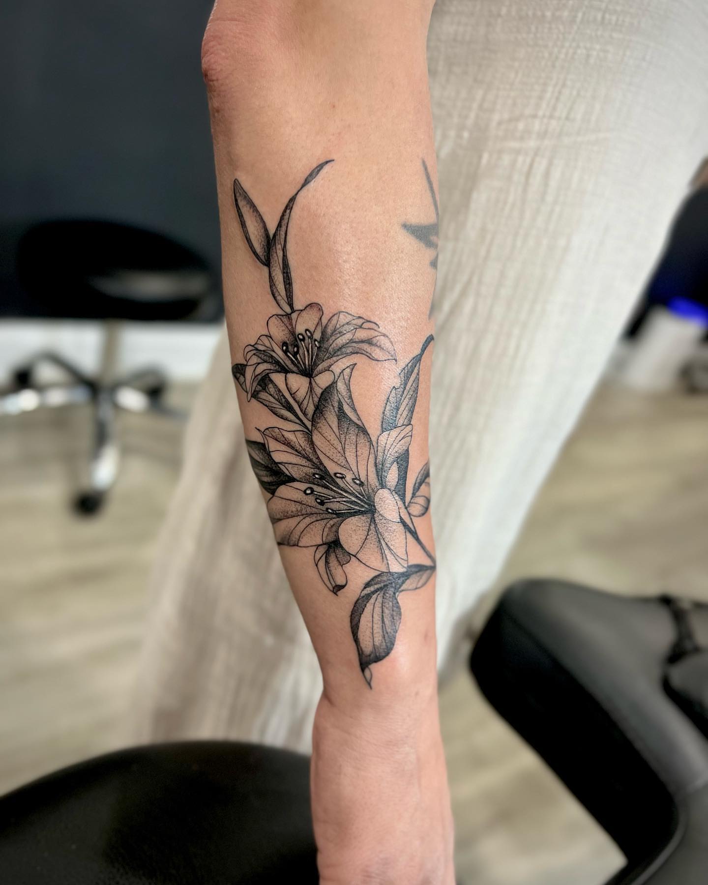 Lilies black and grey tattoo on the forearm by Alfonso Duenas