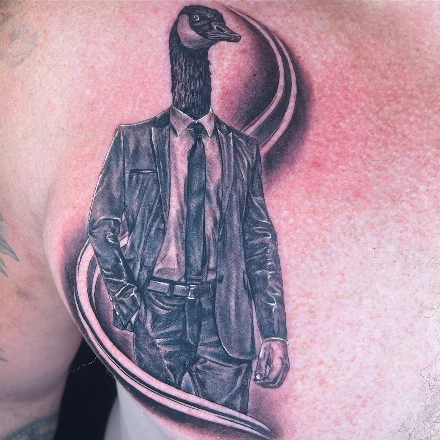 Goose in suit realism tattoo on the chest by Stacy Lavette