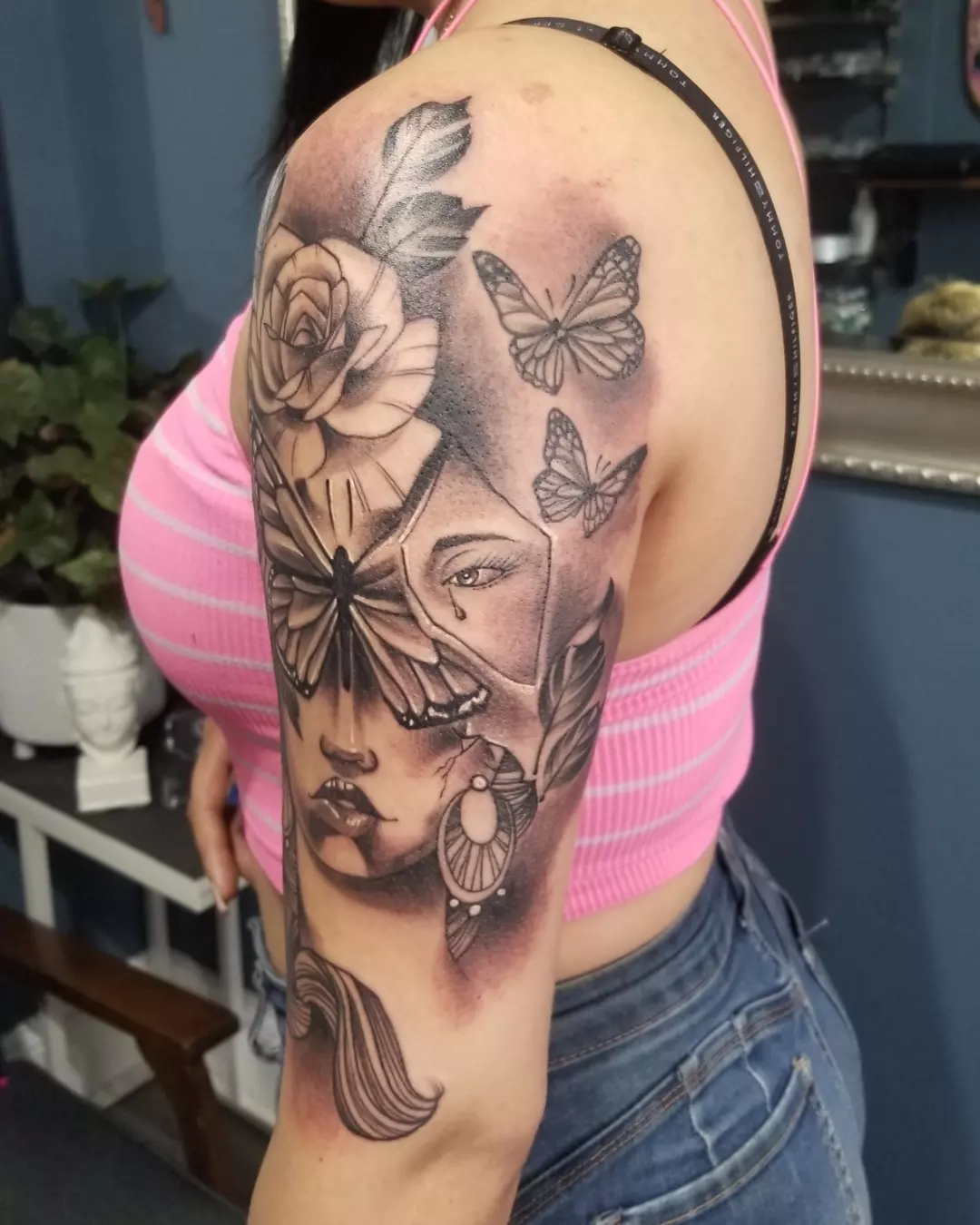 Woman's face with butterflies realism tattoo on the shoulder by German Romero-Rendon