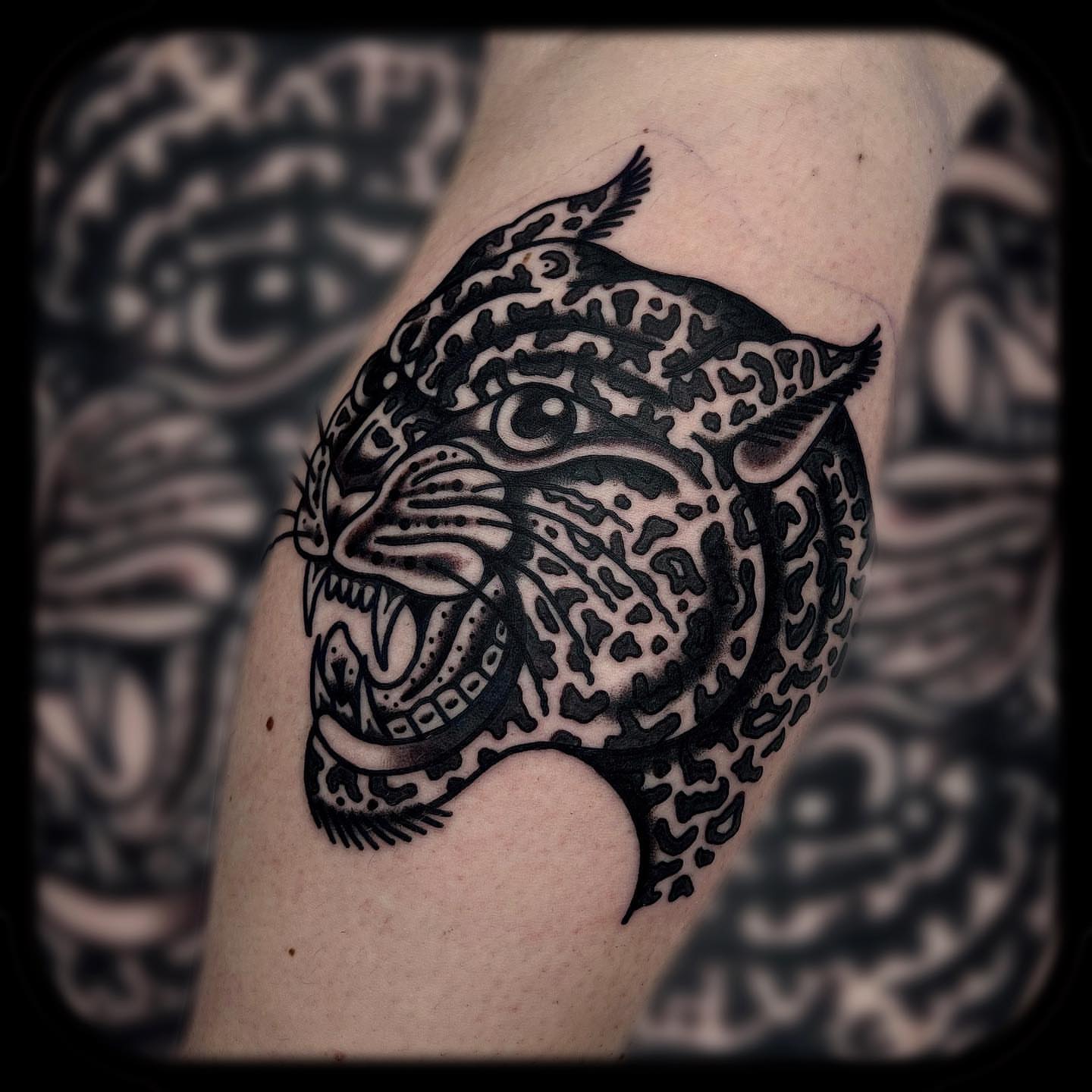 Jaguar head black and grey tattoo on the forearm by Benjamin Ward
