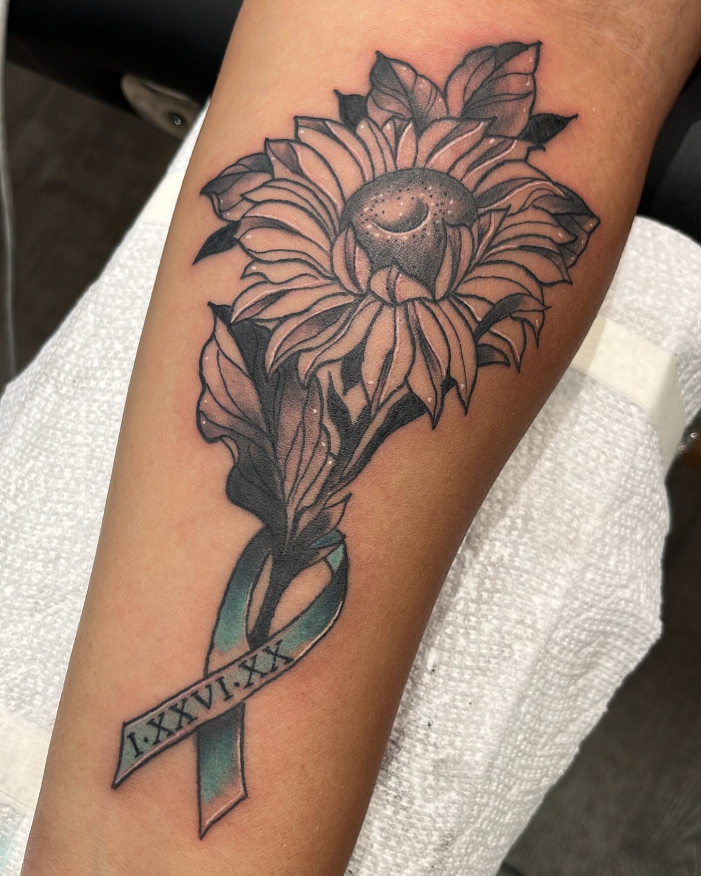 Sunflower and ribbon black and grey tattoo on the forearm by Edward A. Boesch