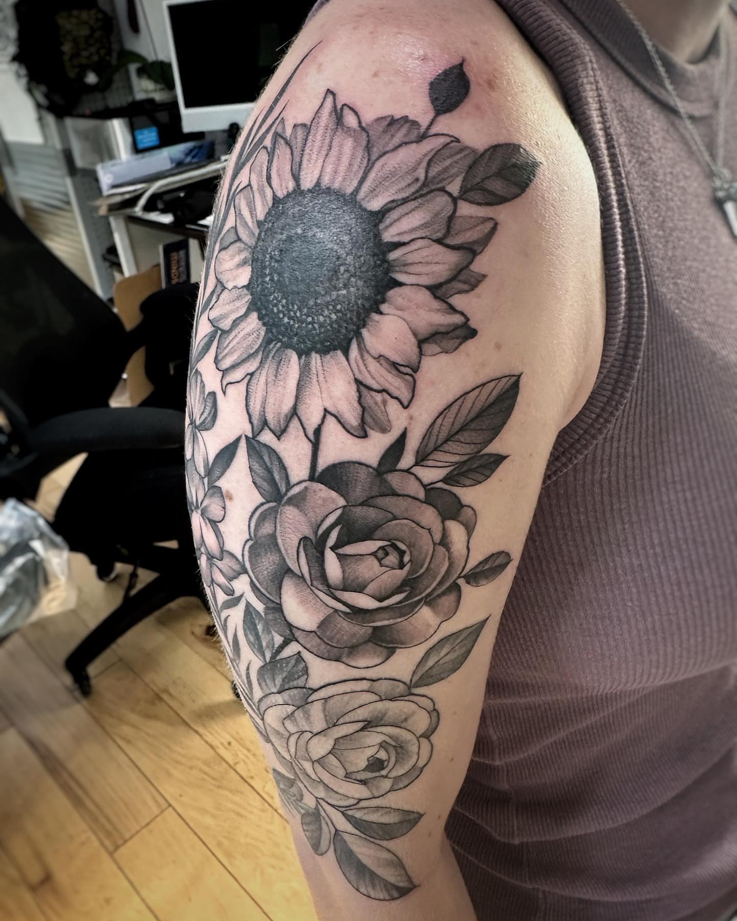 Sunflower and roses black and grey tattoo on the upper arm by David Gray
