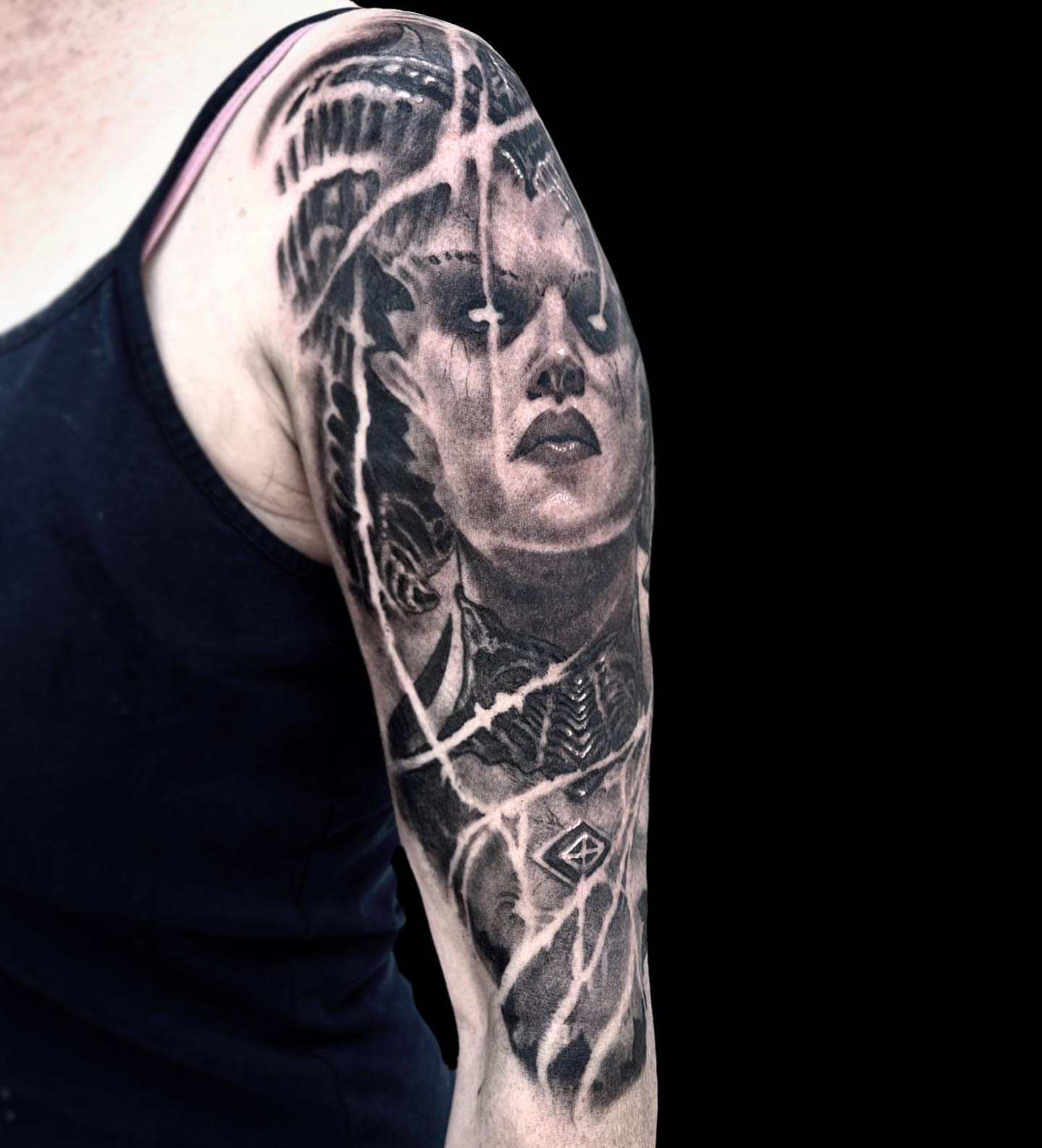 Woman's face realism tattoo on the upper arm by Briana Walker