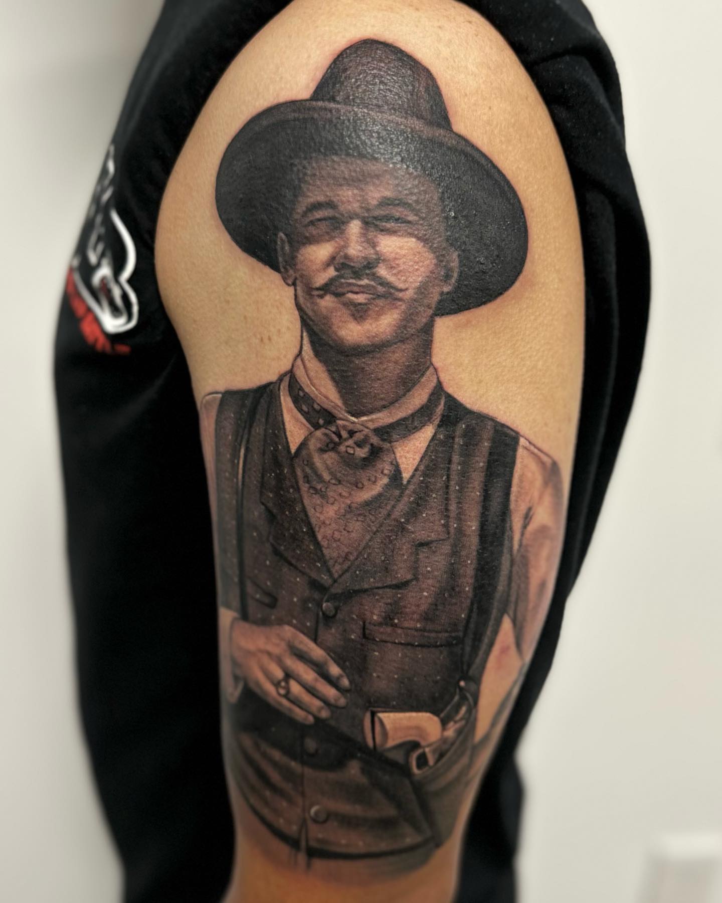 Man in cowboy attire realism tattoo on the forearm by Junior Nunez